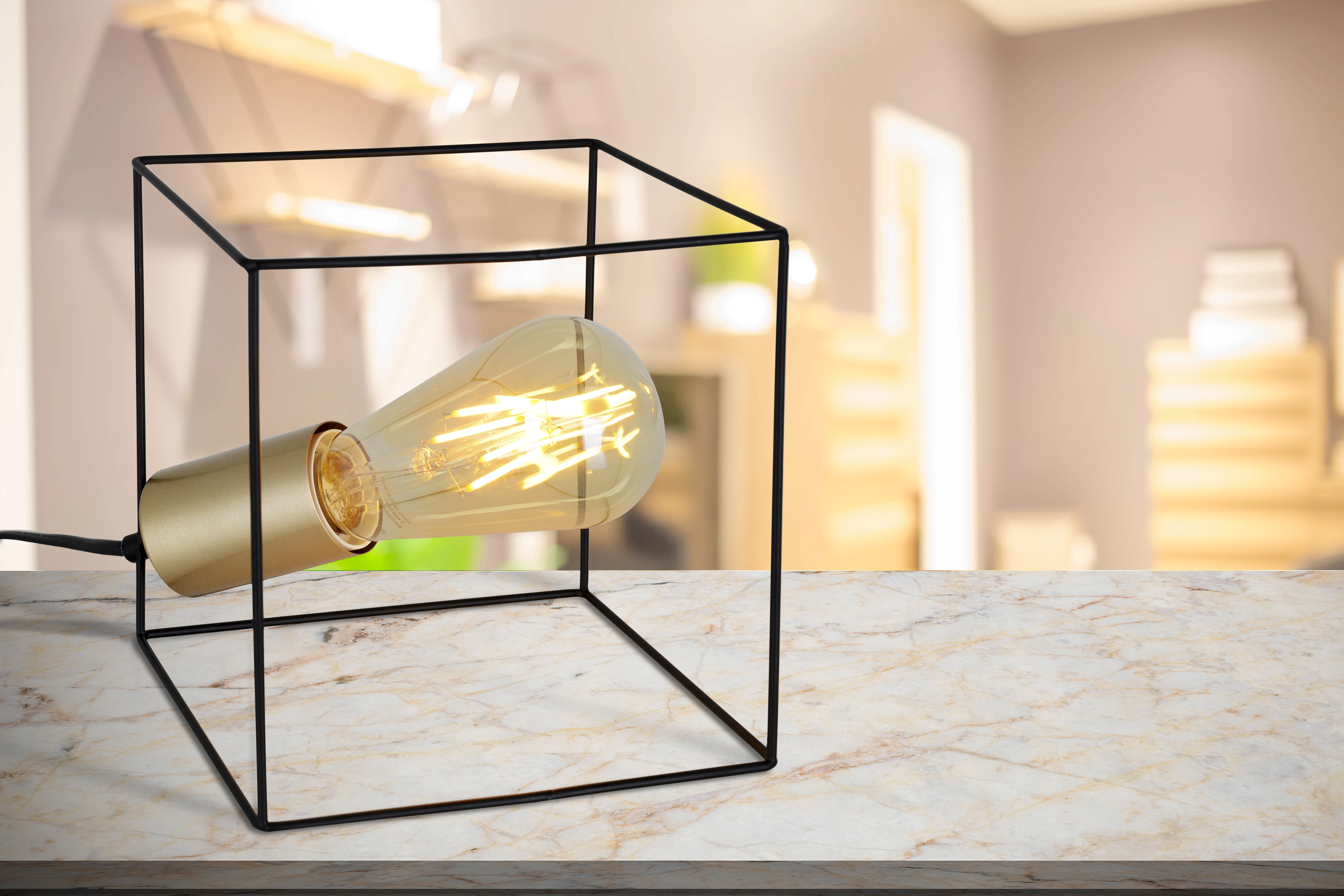 Eine Lampe mit goldenem Sockel und schwarzem Rahmen auf Marmoroberfläche.