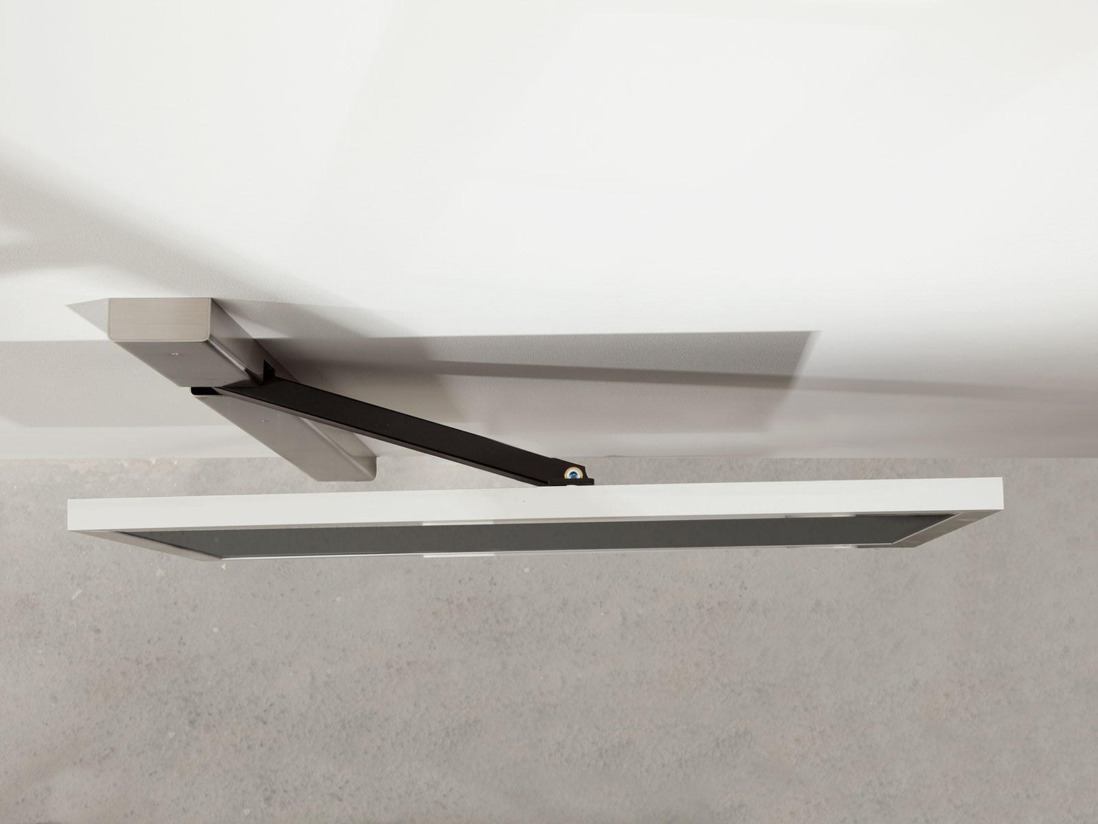 An der Decke montierter, weißer und schwarzer, verstellbarer Arm mit einer rechteckigen weißen Leuchte.