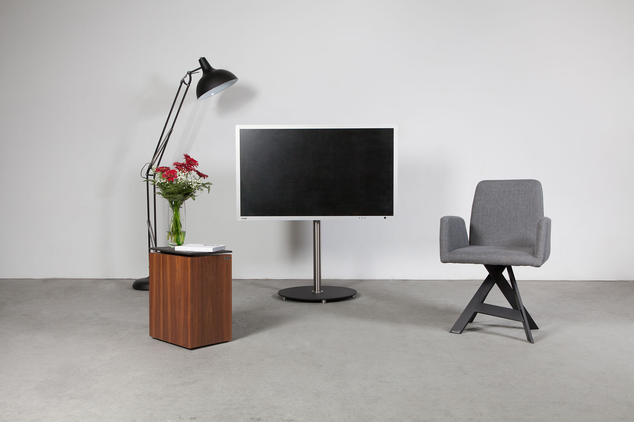 Modernes Interieur mit Fernseher auf Ständer, Stuhl, Beistelltisch und Lampe.