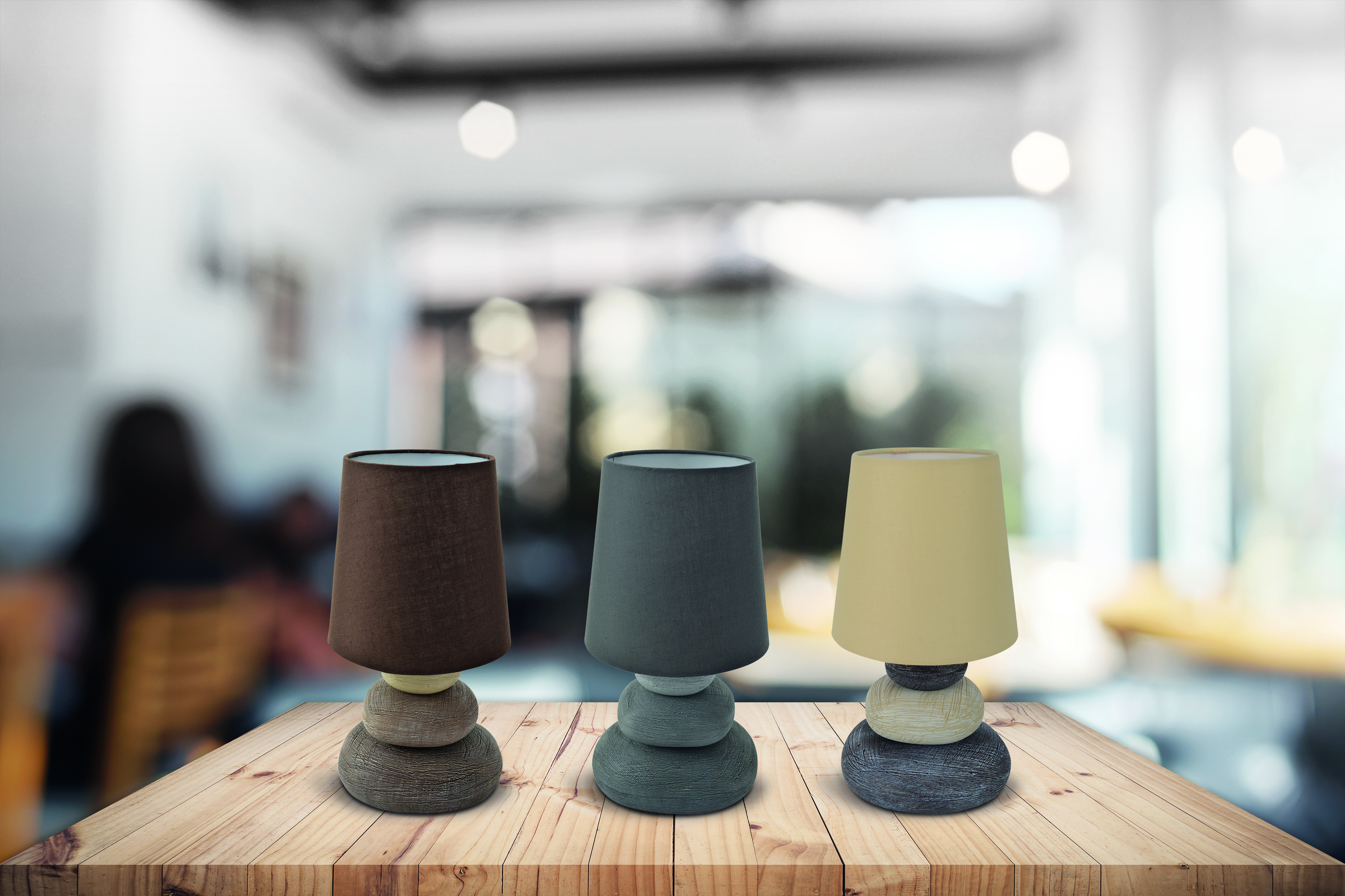 Drei Lampen auf einem Holztisch mit verschwommenem Hintergrund.