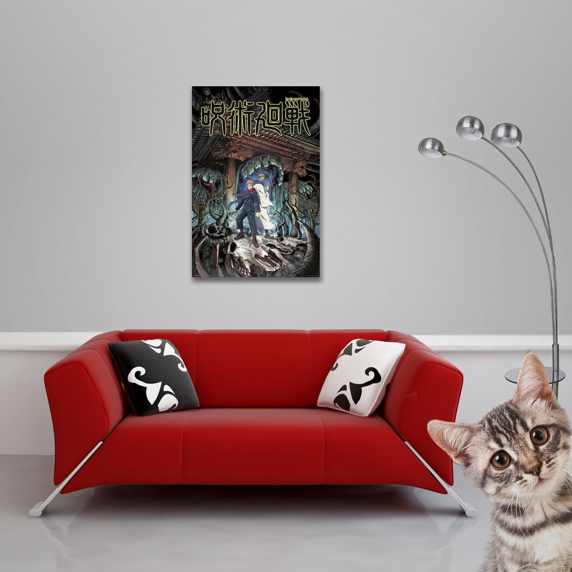 Rotes Sofa mit Kissen und Poster in einem Raum, eine Katze in der Ecke.