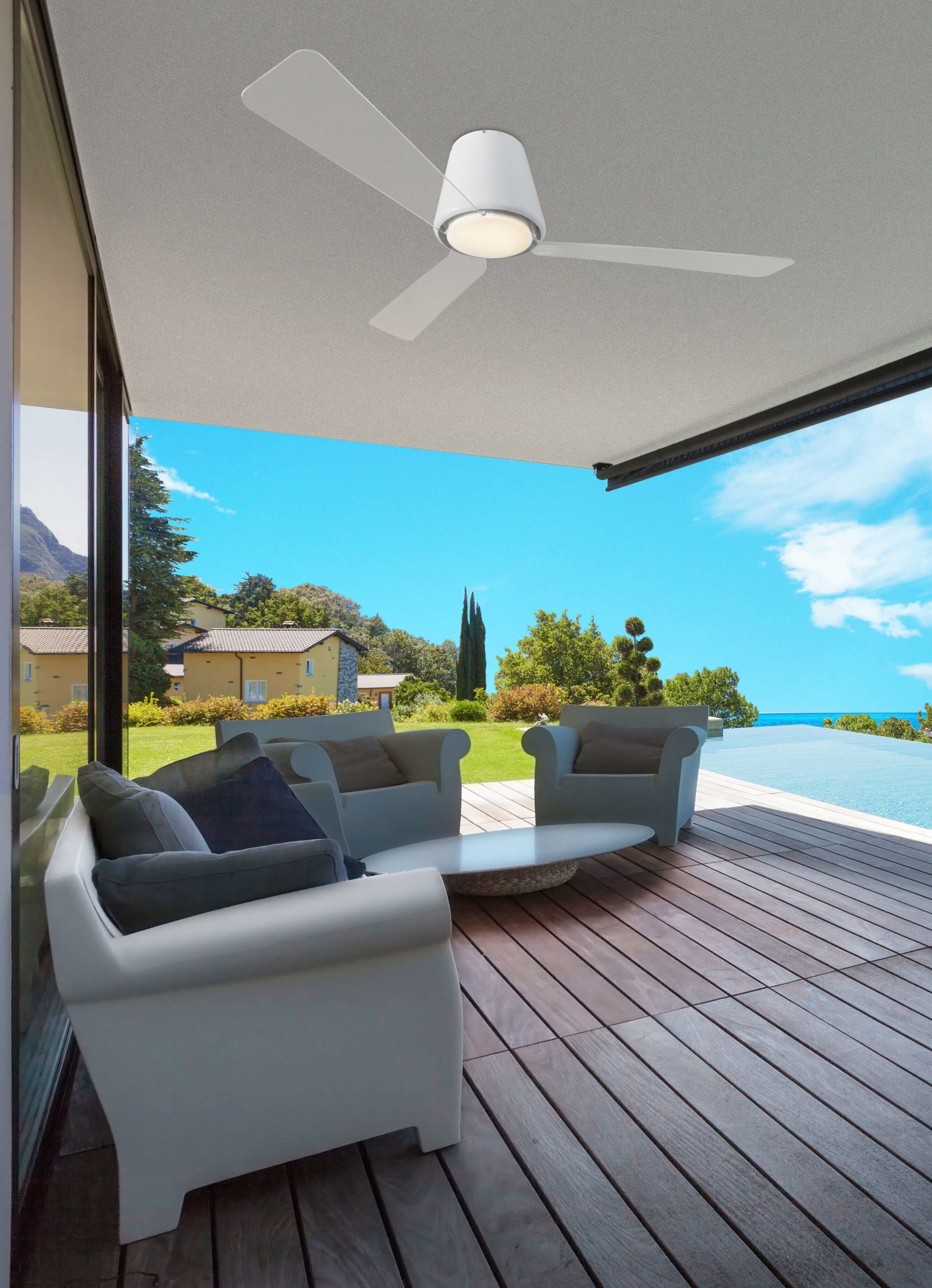 Moderne Außenterrasse mit Deckenventilator, Sofas und Blick auf See und blauen Himmel.