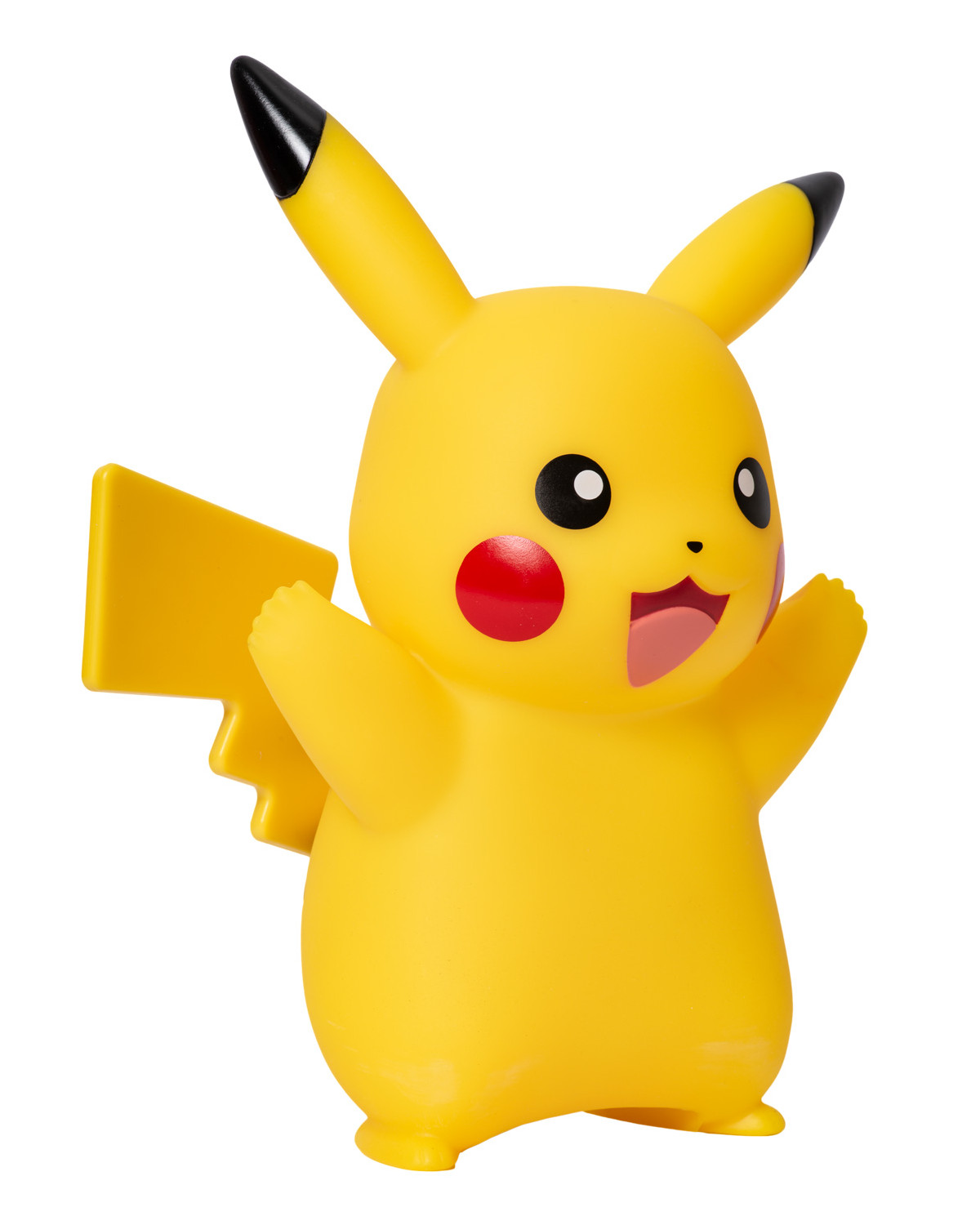 Un giocattolo giallo di Pikachu in piedi su una superficie bianca, braccia alzate e sorridente.