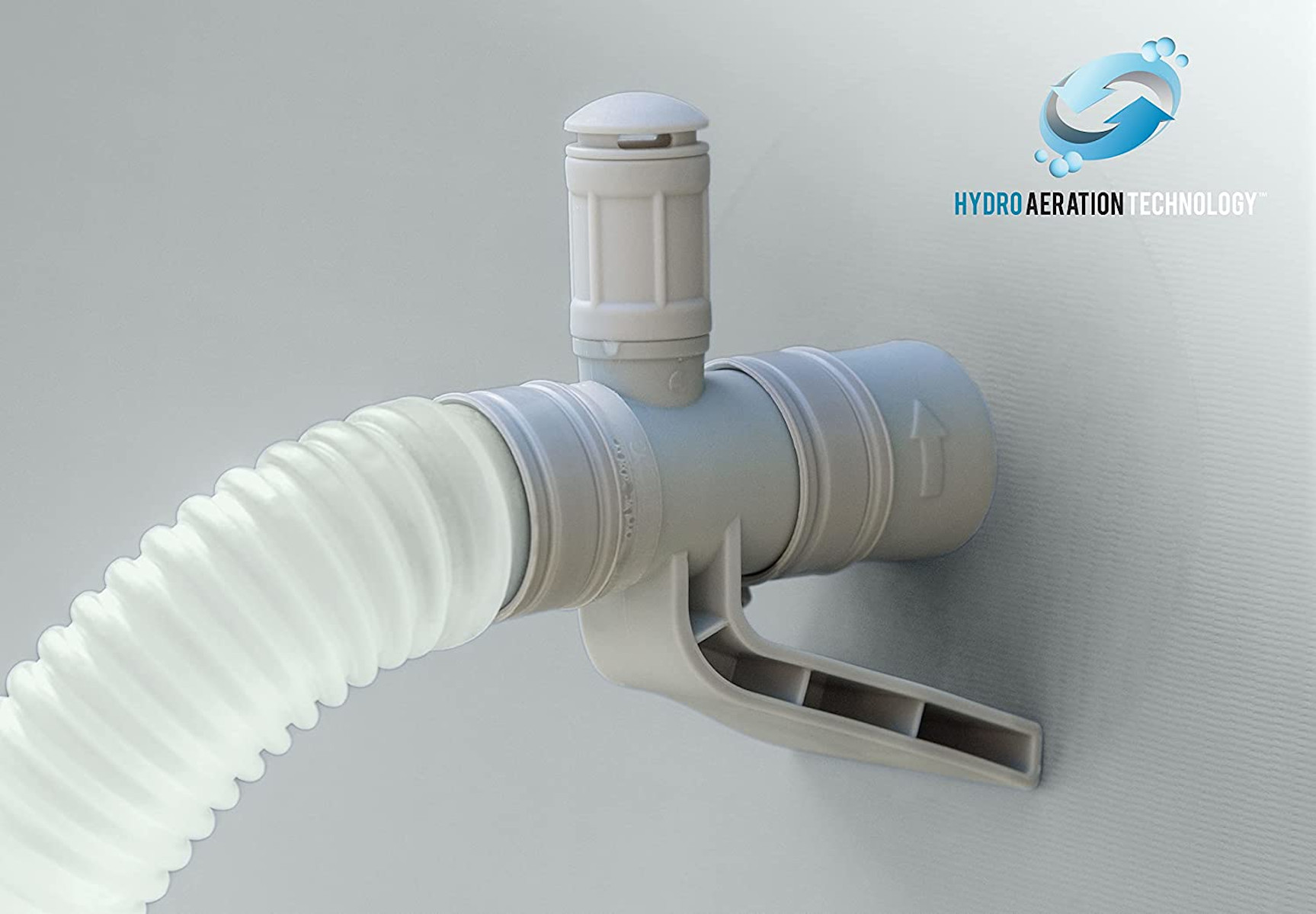 Ein Wasserventil, an einem weißen Schlauch befestigt. Grauer Hintergrund. Text: 'Hydro Aeration'.