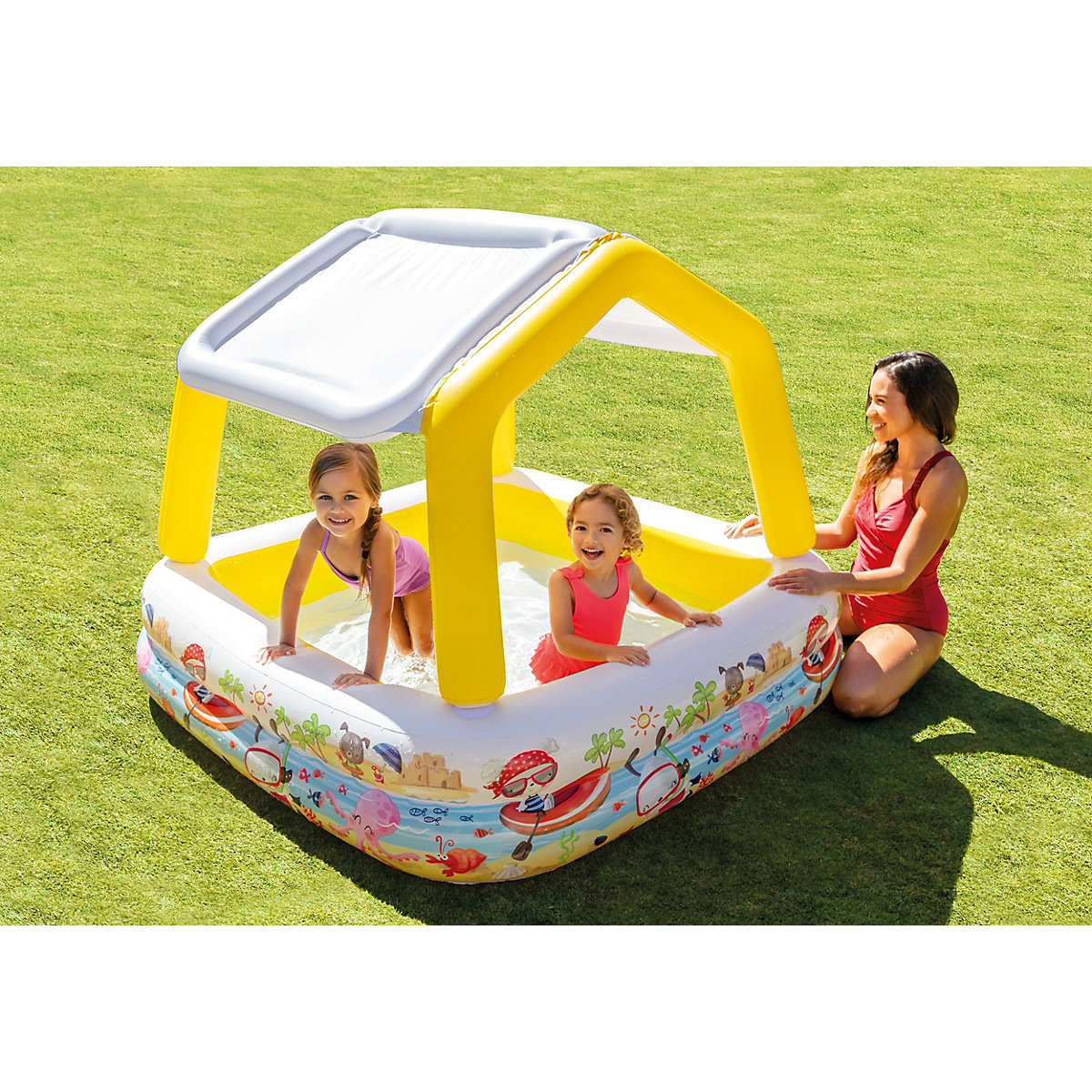 Kinder spielen in einem kleinen aufblasbaren Pool mit Sonnensegel.