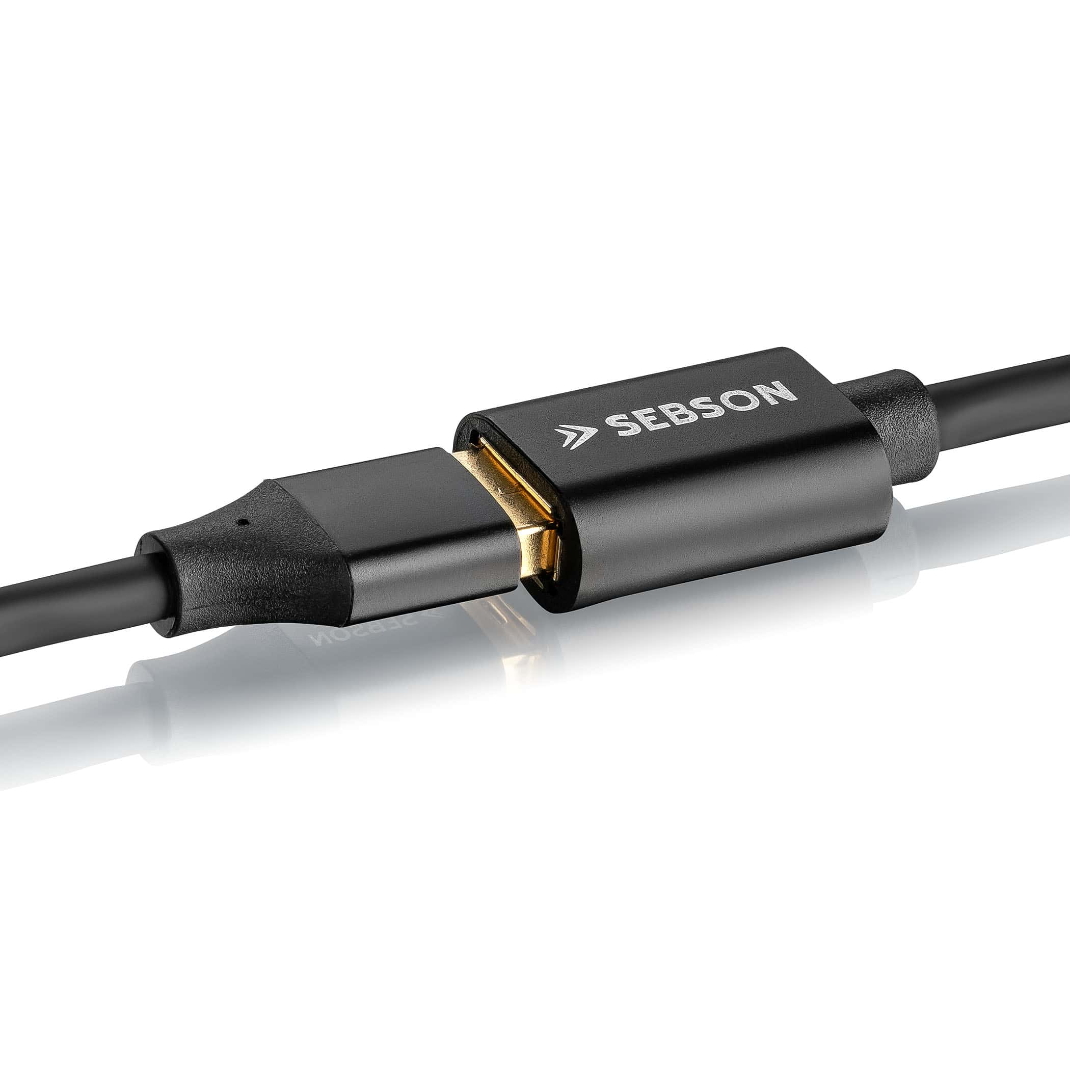 Schwarzes und goldenes USB-C-Kabel. Das Kabel ist an einen schwarzen Anschluss angeschlossen. Weißer Hintergrund.