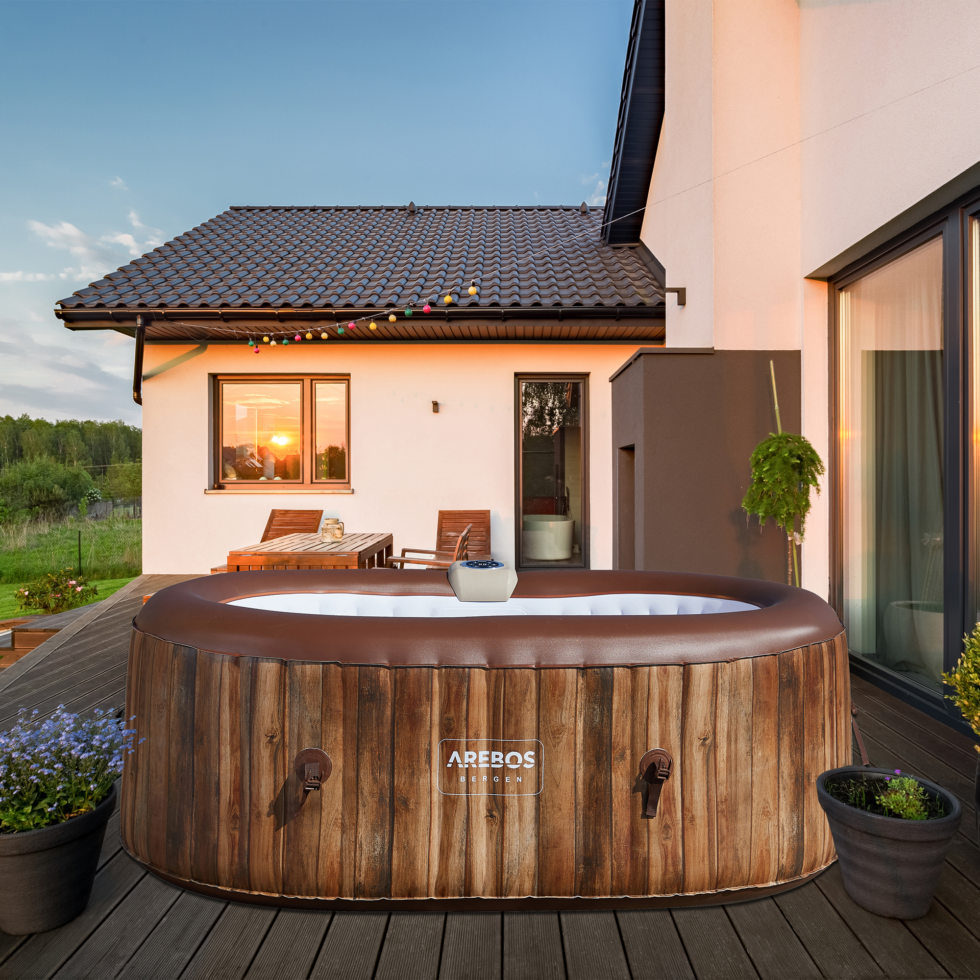 Ein holzartig aussehender Whirlpool mit brauner Außenseite, auf einer Holzterrasse vor einem Haus.