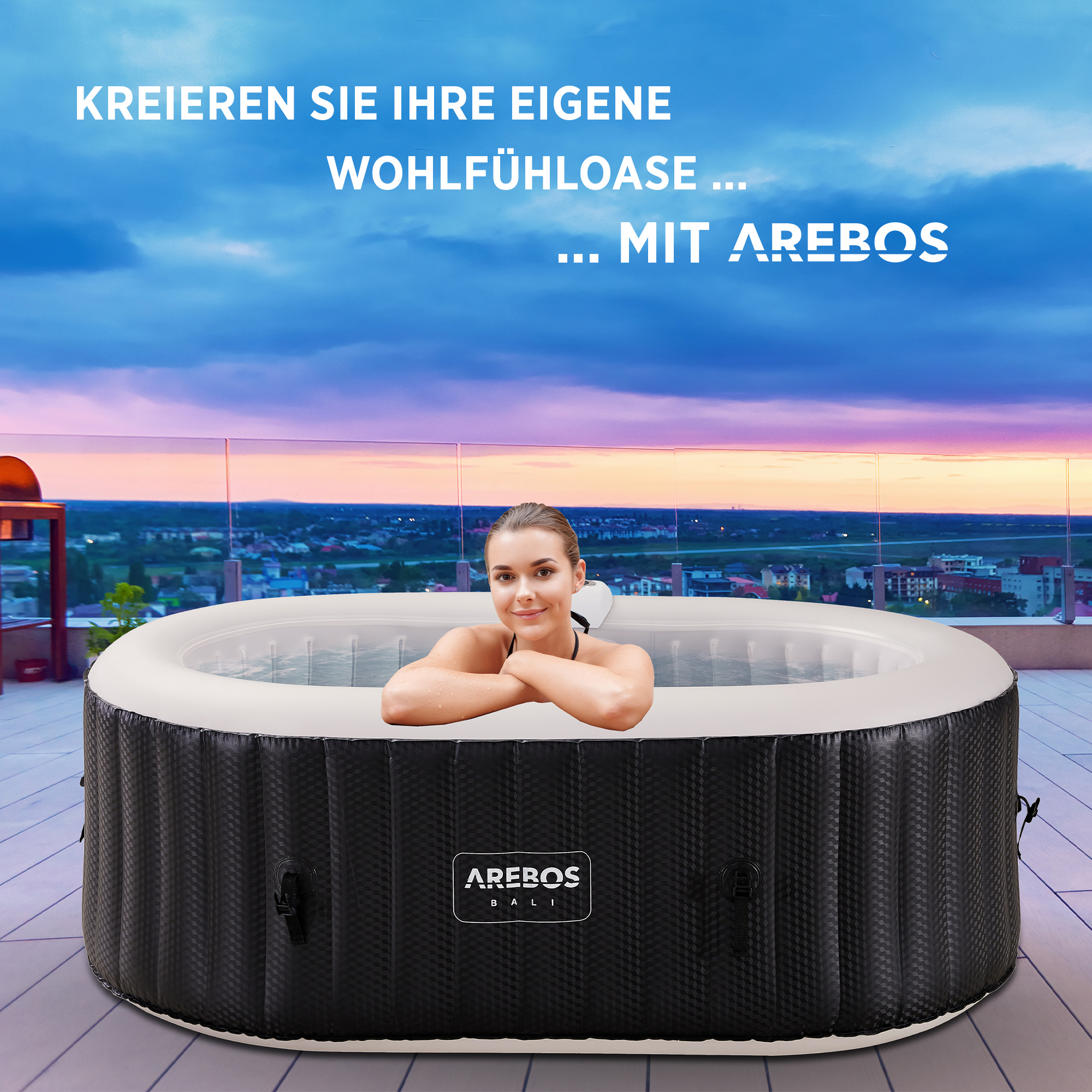 Eine Frau in einem Whirlpool auf einem Dach, mit einer Stadt und Sonnenuntergang im Hintergrund. Der Pool ist schwarz.