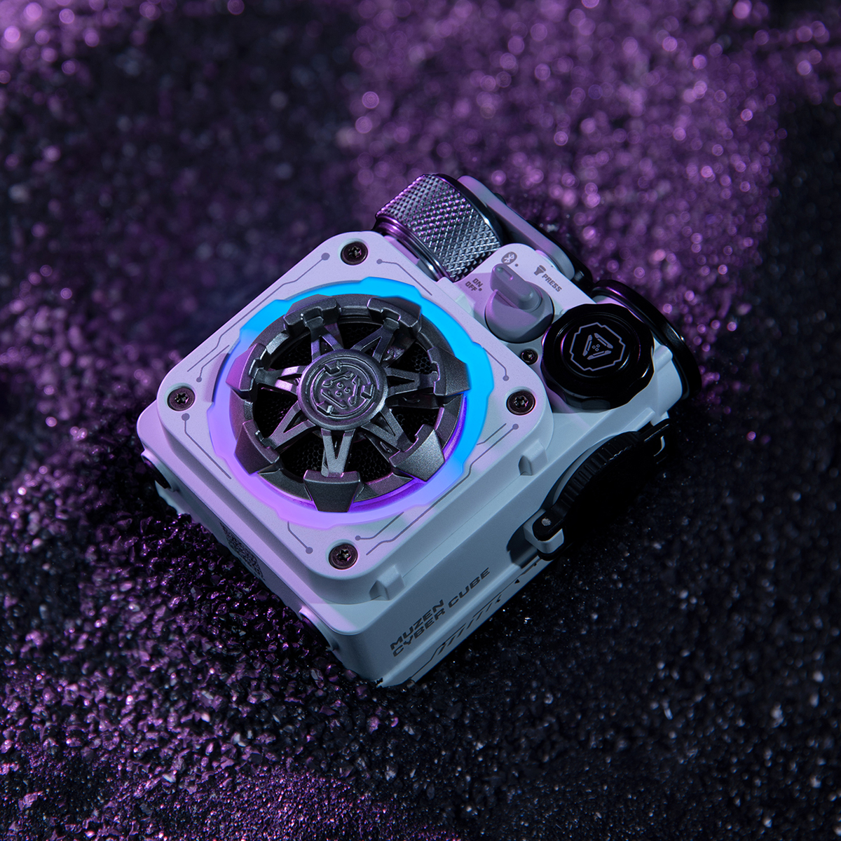 Ein weiß-grauer Lautsprecher mit blau-violetten Lichtern. Dunkler Hintergrund mit glänzenden Punkten.