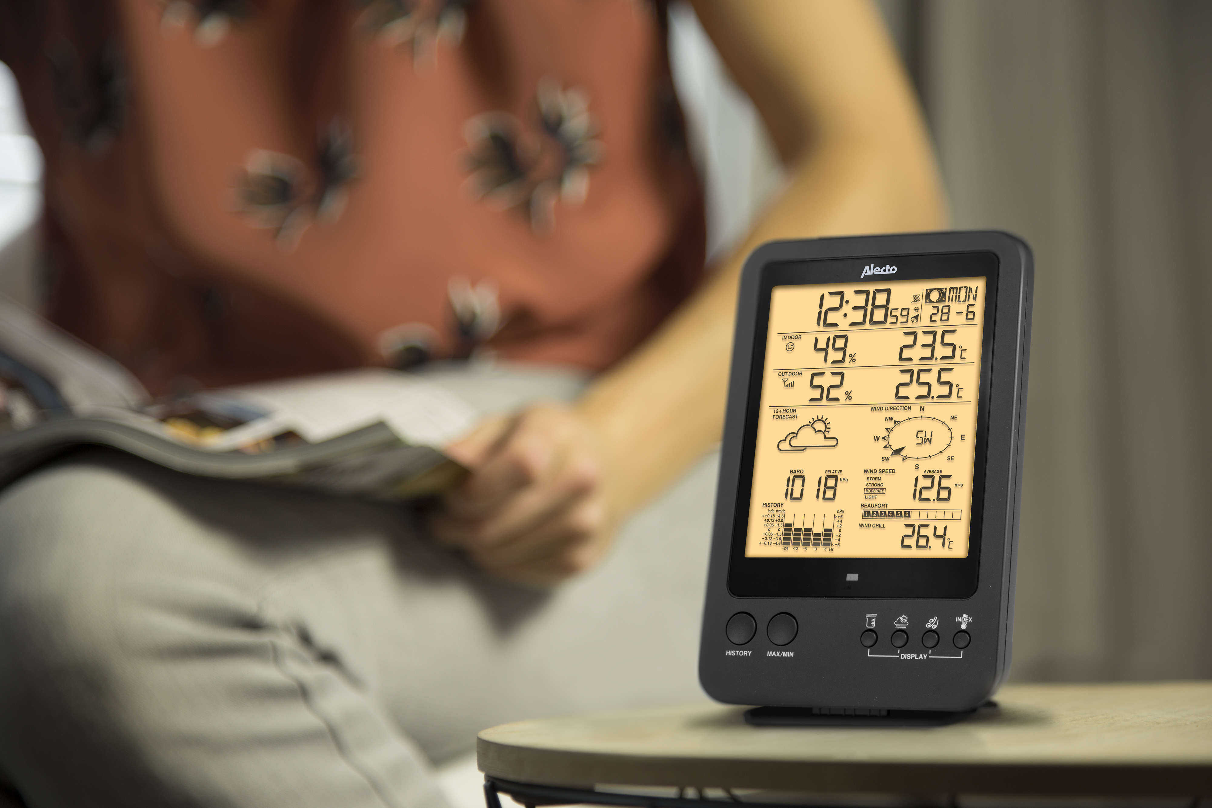 Una stazione meteorologica digitale che mostra ora, data, umidità e condizioni meteorologiche su un tavolo.