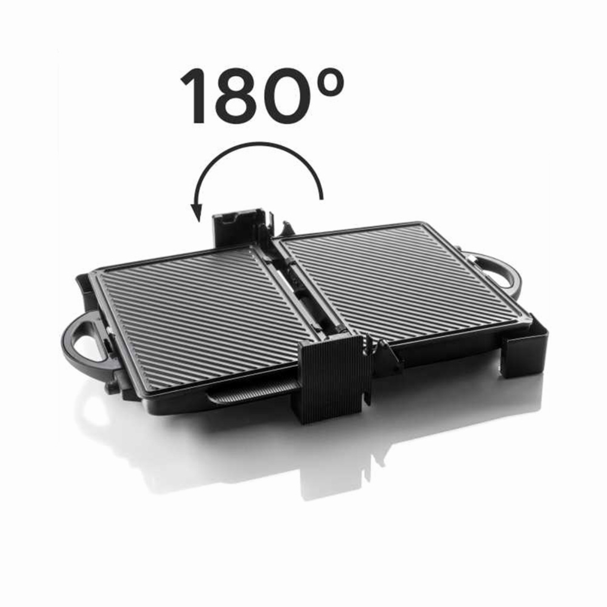 Parrilla negra y plateada, abierta 180 grados. La parrilla tiene superficies acanaladas y asas en ambos lados.