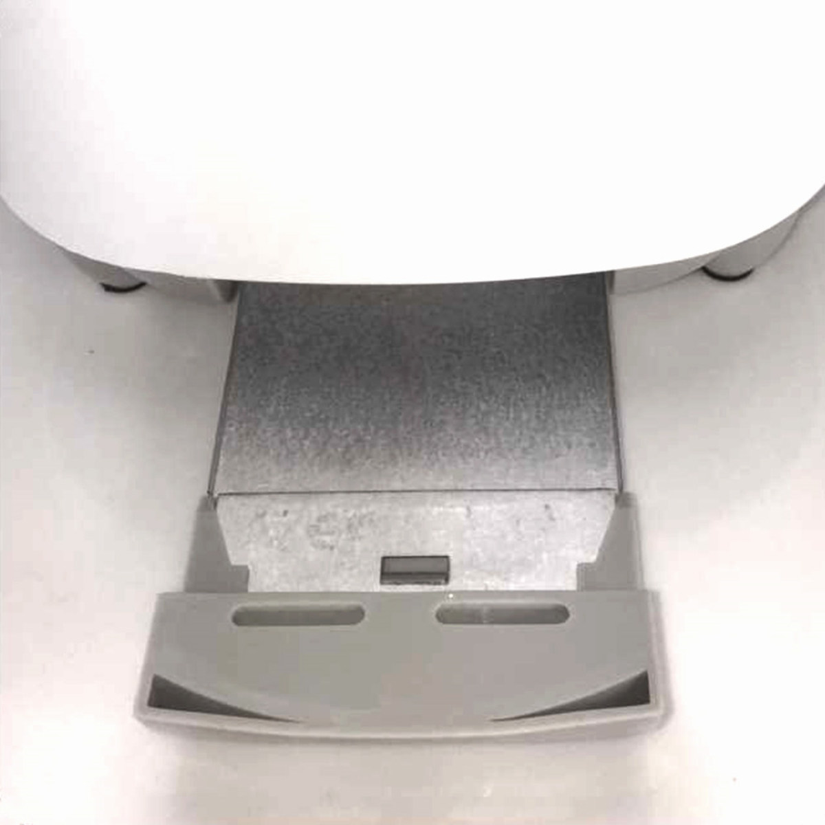 Białe urządzenie z szarą prostokątną podstawą i białym, zaokrąglonym wierzchem.