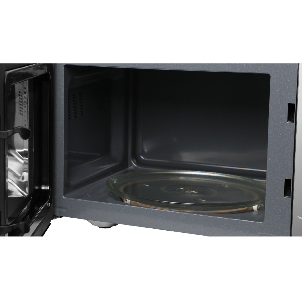 Wnętrze kuchenki mikrofalowej ze szklanym talerzem, otwartymi drzwiami i ciemnoszarymi ścianami.