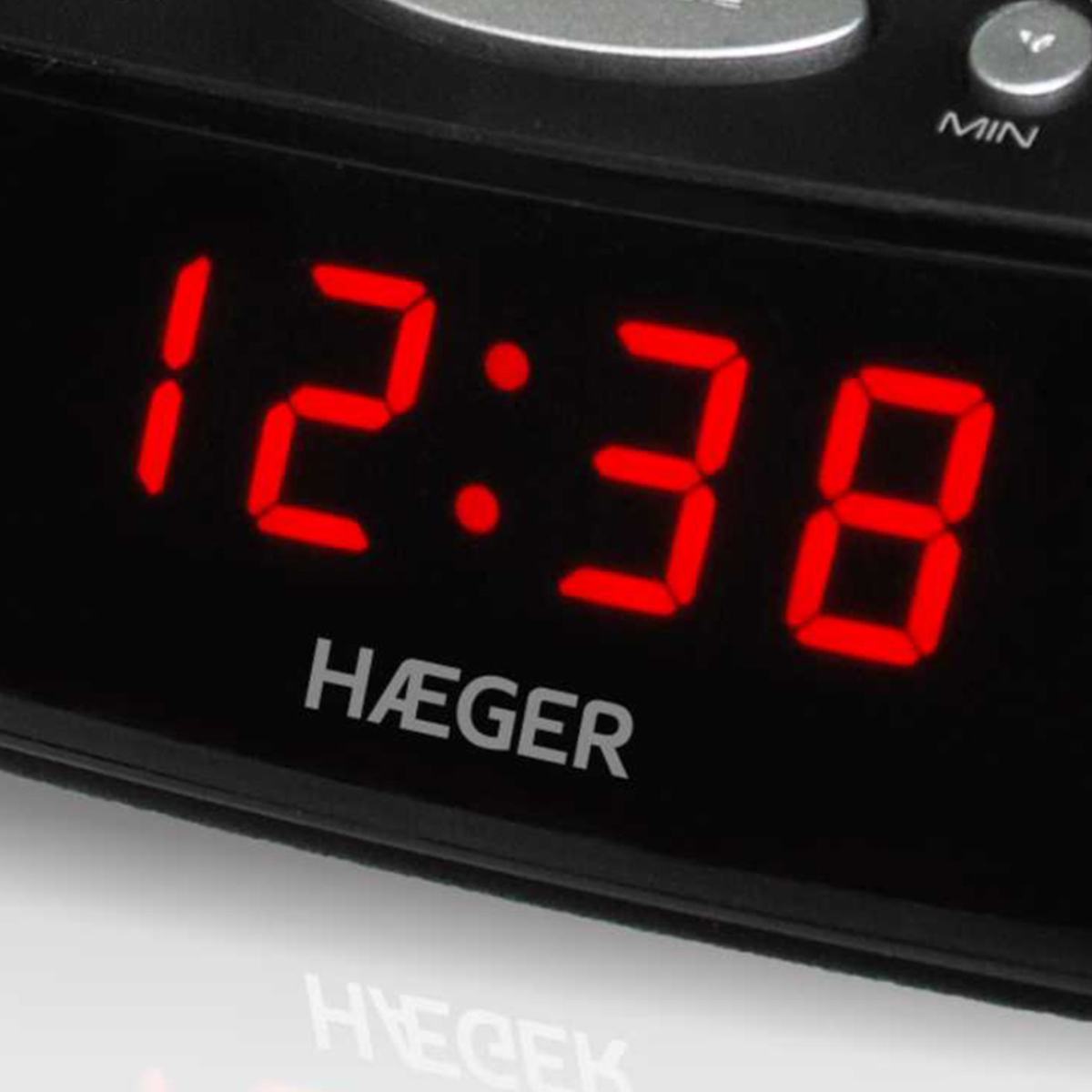 Orologio digitale che mostra 12:38 in cifre rosse, con il marchio 'HAEGER'.