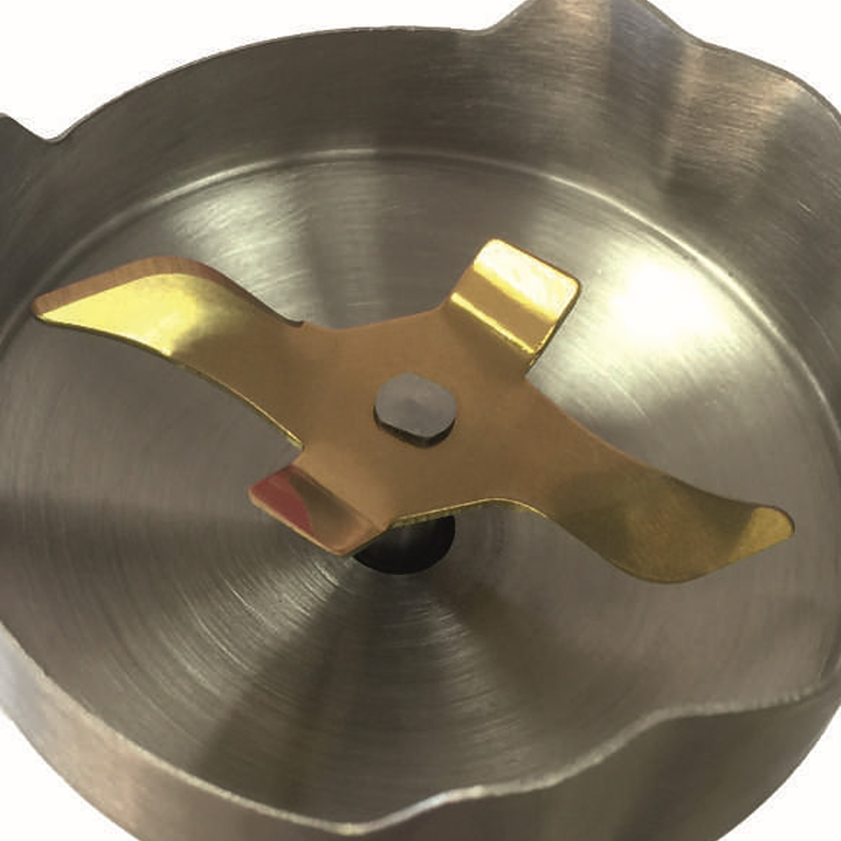 Zbliżenie ostrza blendera. Ostrze jest złote i wewnątrz miski ze stali nierdzewnej.