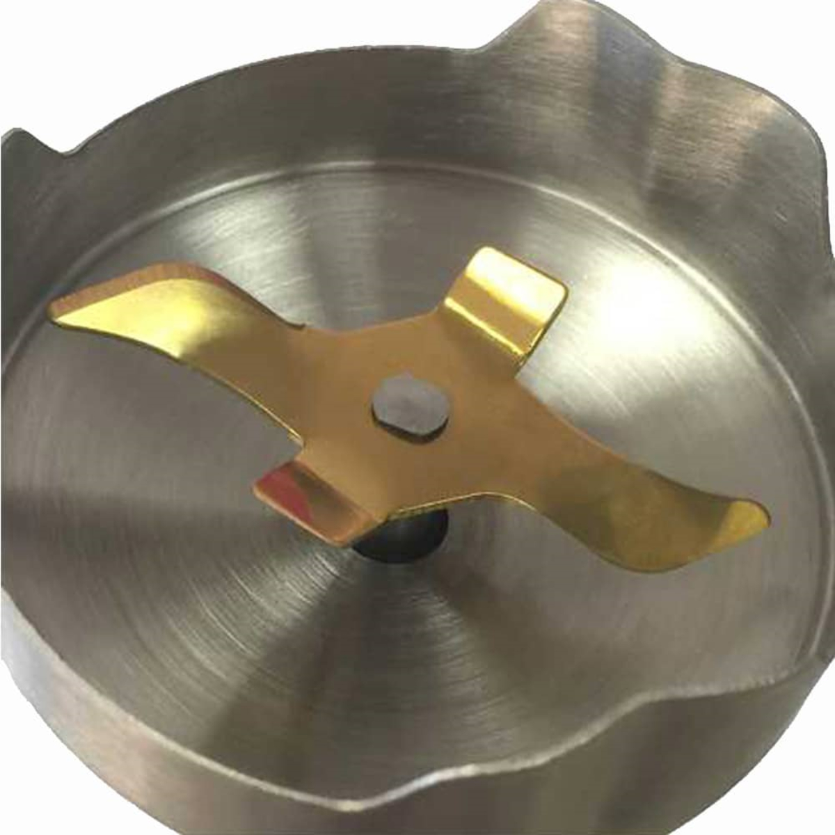 Zbliżenie ostrza blendera zanurzeniowego. Ostrze jest złote i ma unikalny kształt.