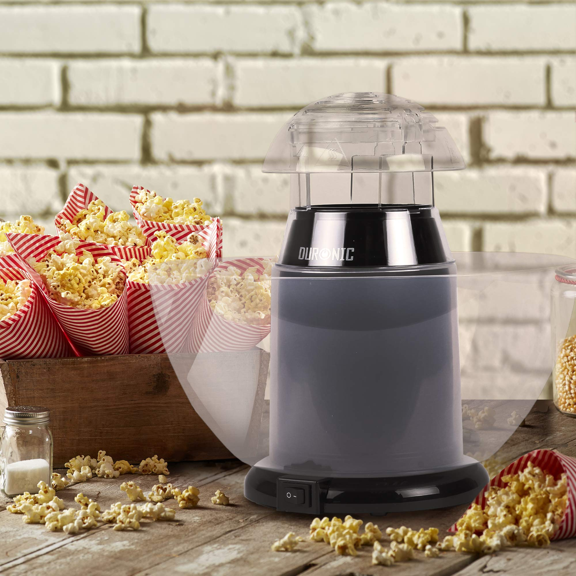Eine Popcornmaschine mit Popcorn in rot-weiß gestreiften Papierkegeln und einer Schüssel Popcorn.