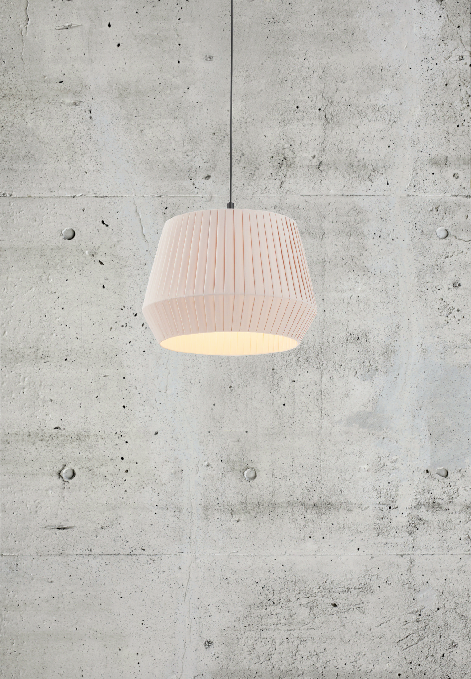 Eine rosa, plissierte Pendelleuchte, die an einem Kabel vor einer Betonwand hängt.