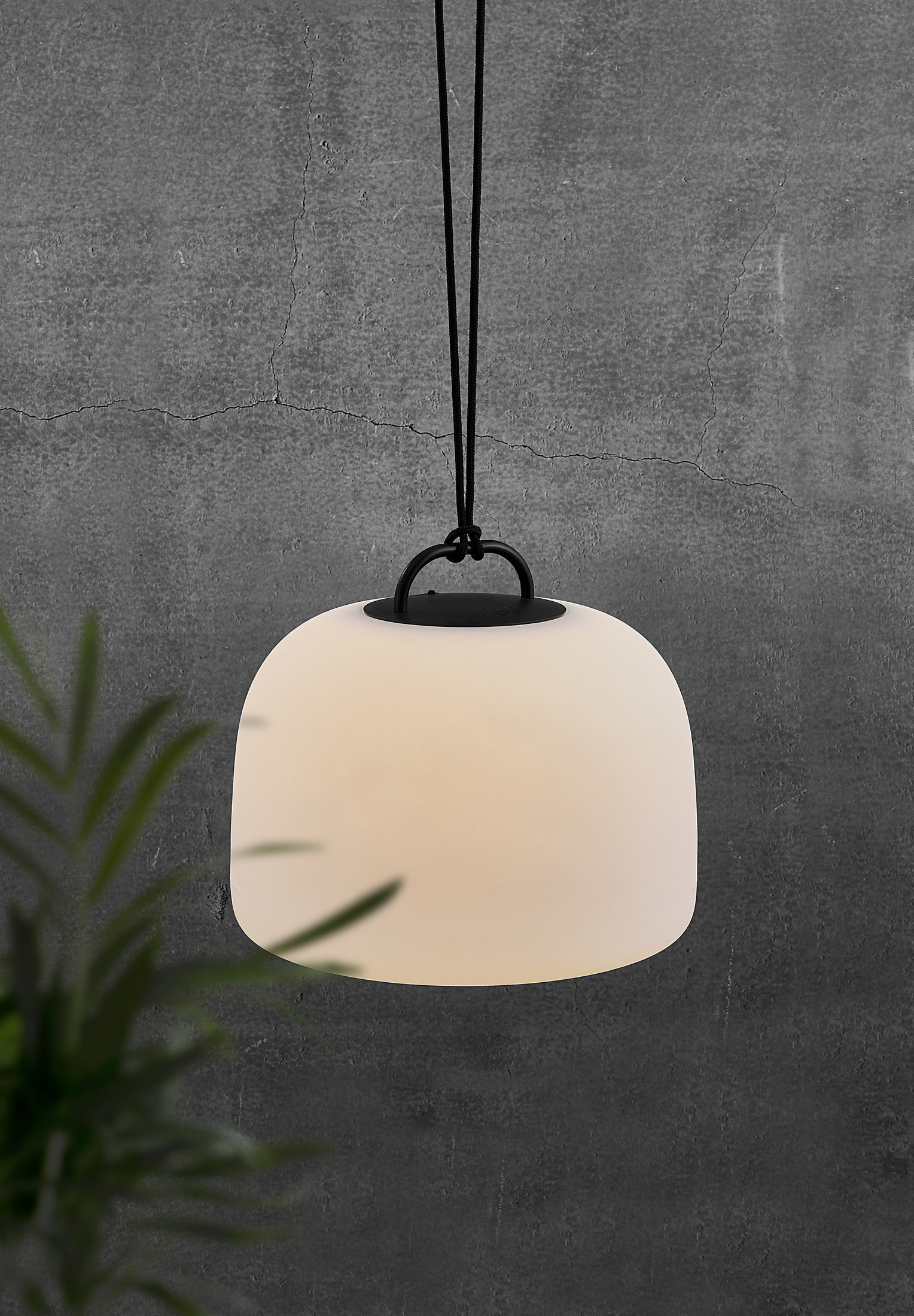 Eine weiße, hängende, abgerundete Lampe mit schwarzem Kabel auf grauem Hintergrund.