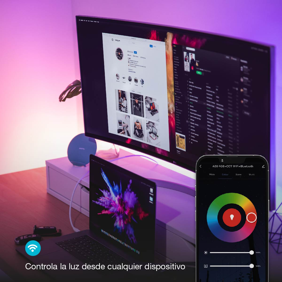 Una mesa con una laptop, monitor y un teléfono que muestra una aplicación de control de color.