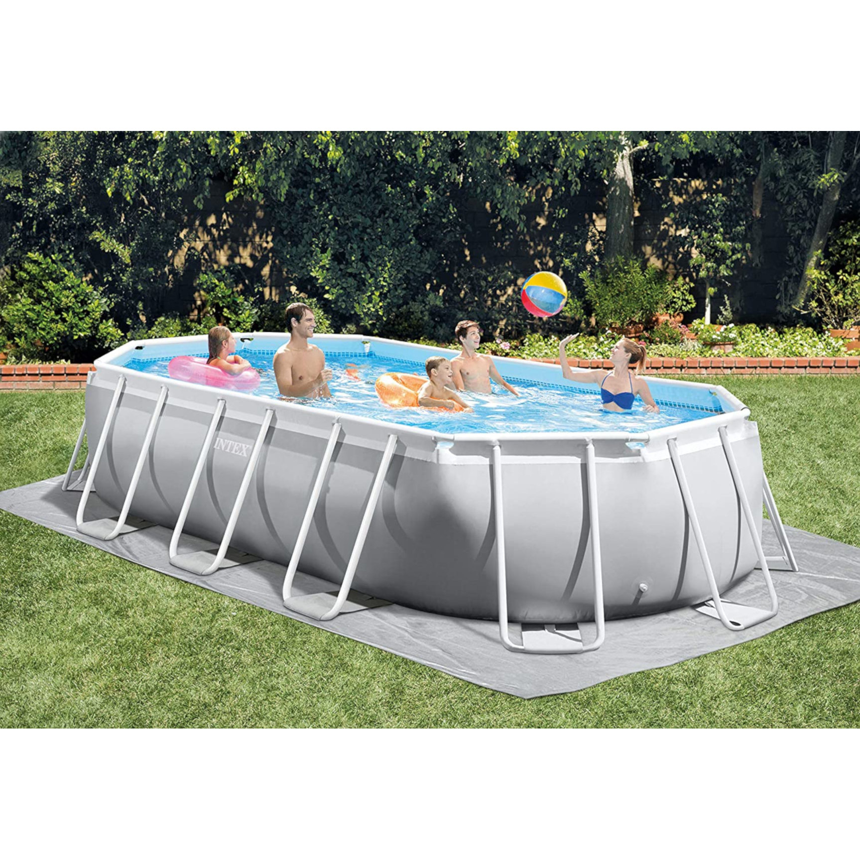 Leute spielen in einem rechteckigen Pool in einem grasbewachsenen Garten an einem sonnigen Tag.