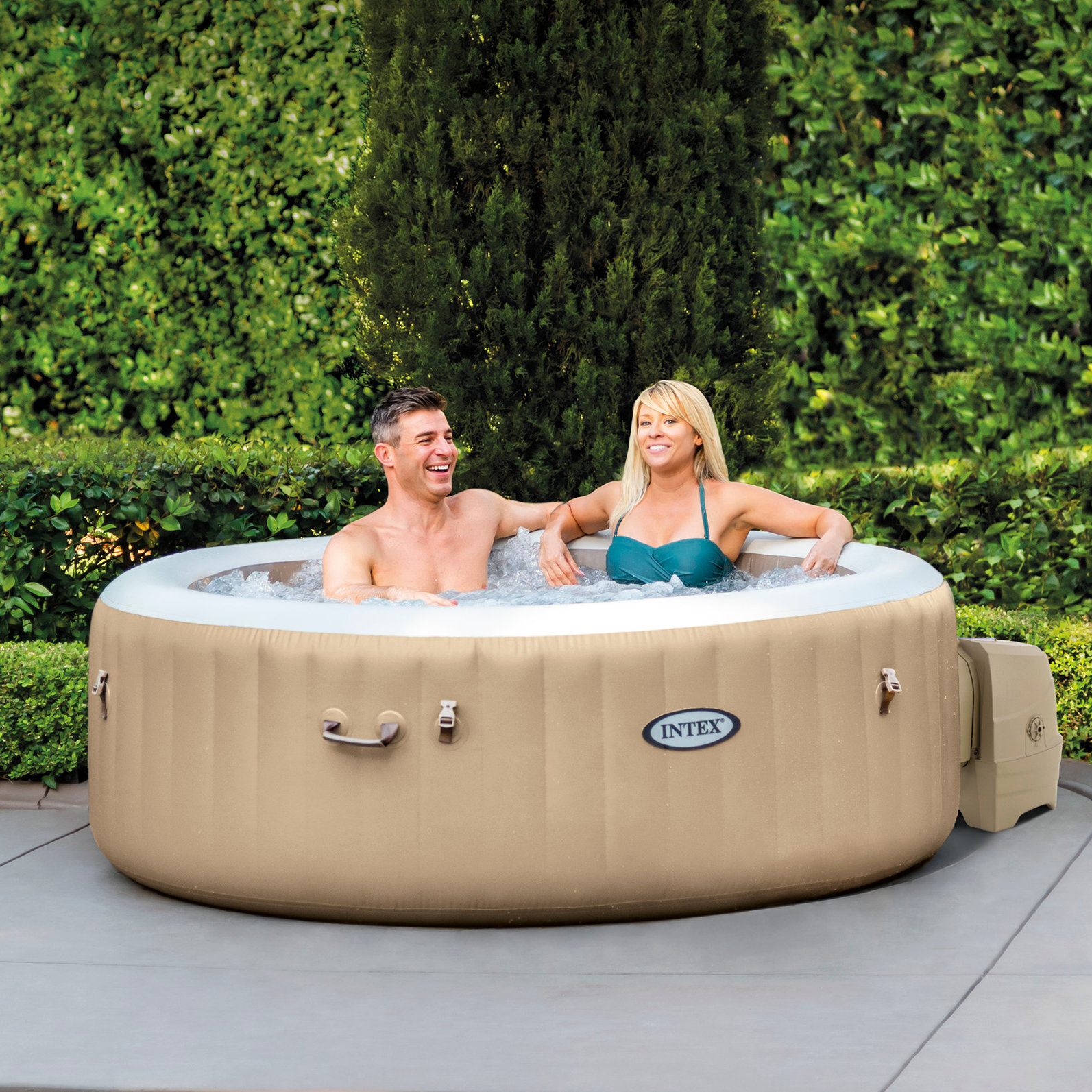 Paar in einem Whirlpool im Freien, mit Bäumen im Hintergrund.