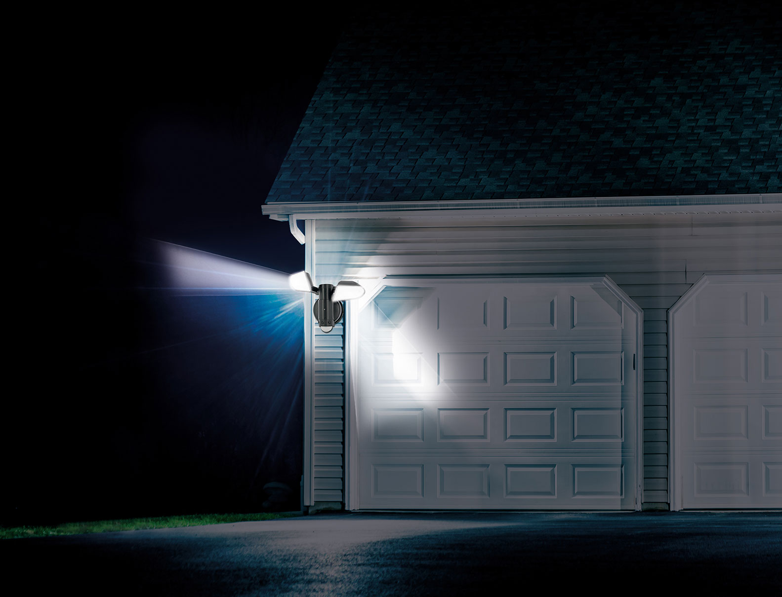 Exterior of a house at night, illuminated by a floodlight on the side.