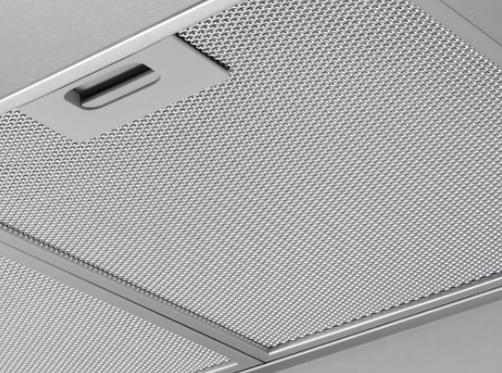 Primer plano de una rejilla metálica, con pequeños agujeros en forma de diamante dispuestos en una cuadrícula.