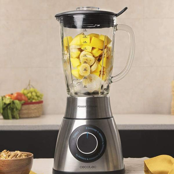 Licuadora con rodajas de mango y plátano. Base de acero inoxidable, jarra de vidrio con medidas.