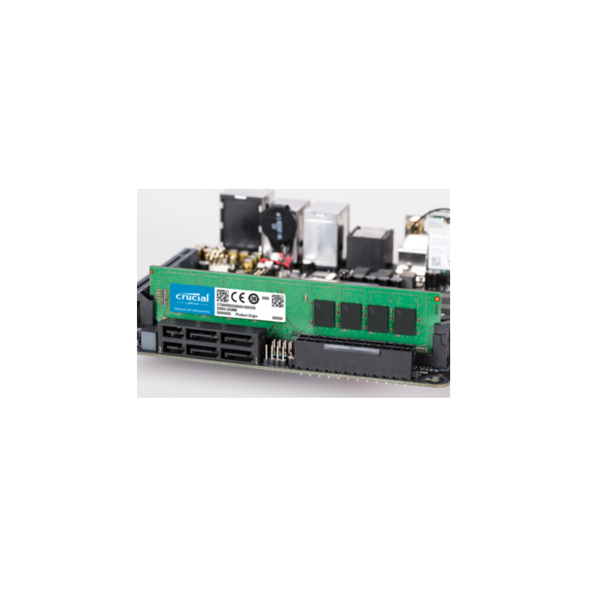 Ein Computer-Motherboard mit installiertem RAM-Stick. Der RAM ist grün und hat das Crucial-Logo.