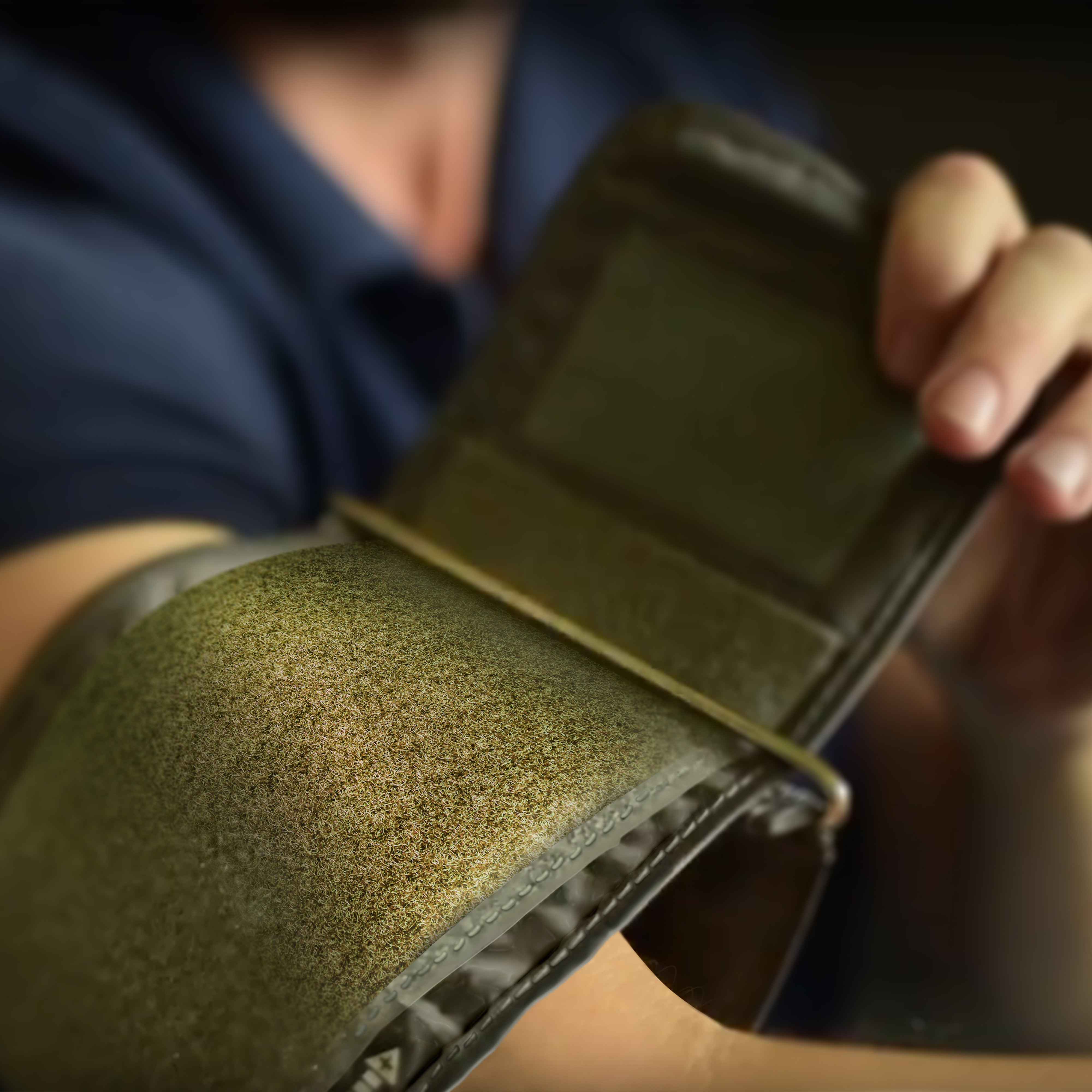 Eine Person trägt eine Blutdruckmanschette. Der Fokus liegt auf der Manschette und dem Arm.
