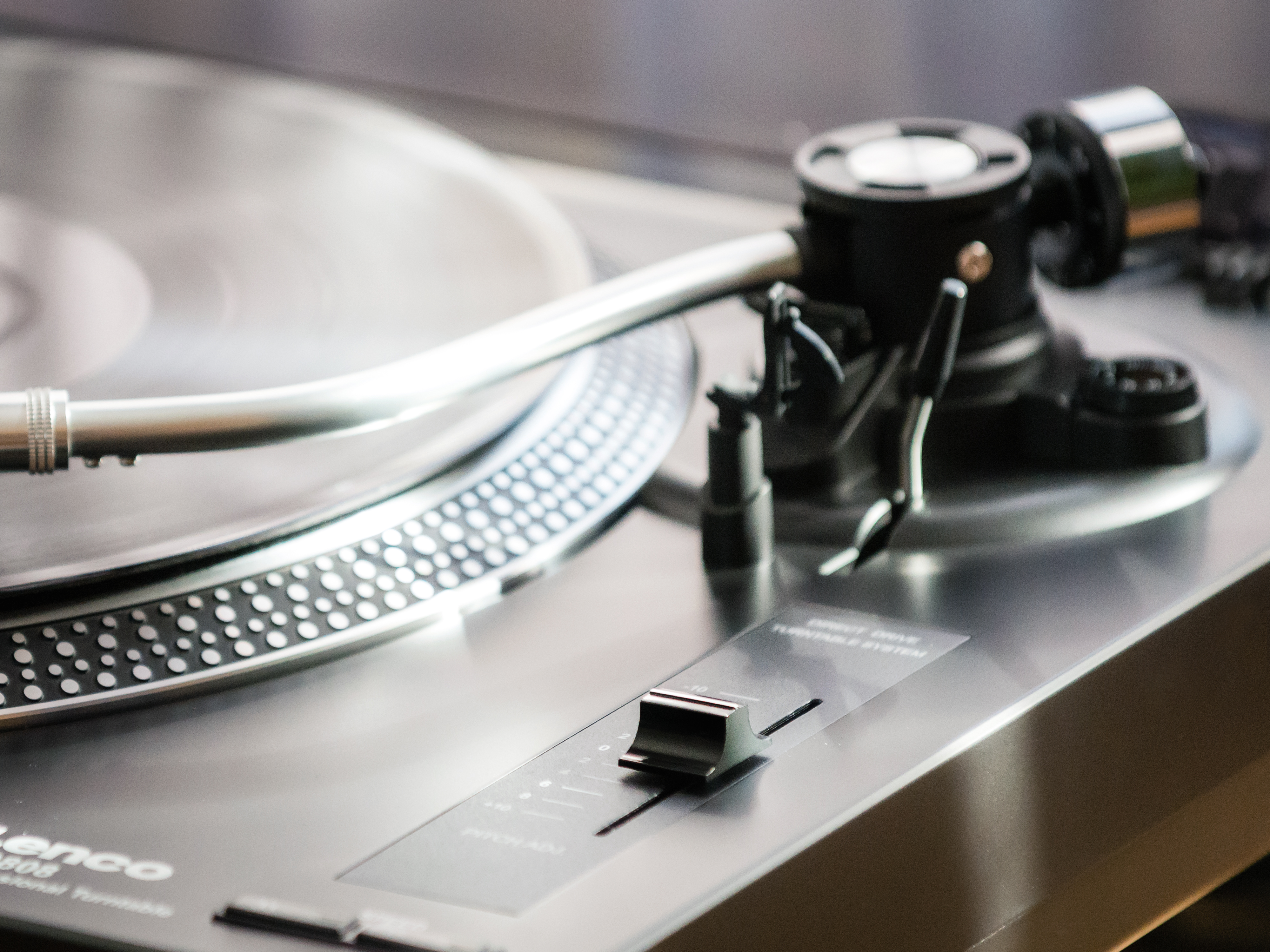 Zbliżenie srebrnego gramofonu. Igła jest na środku płyty.