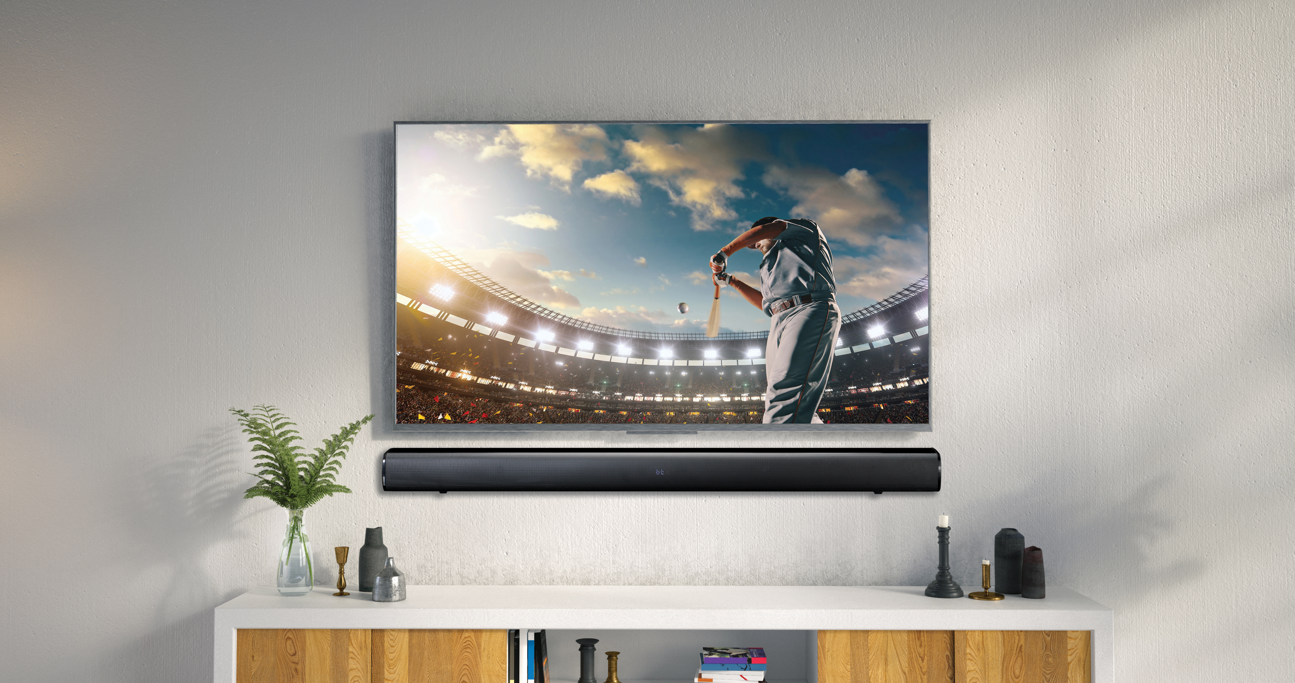 Fernseher auf weißem Schrank, der ein Baseballspiel mit einer Soundbar darunter zeigt.