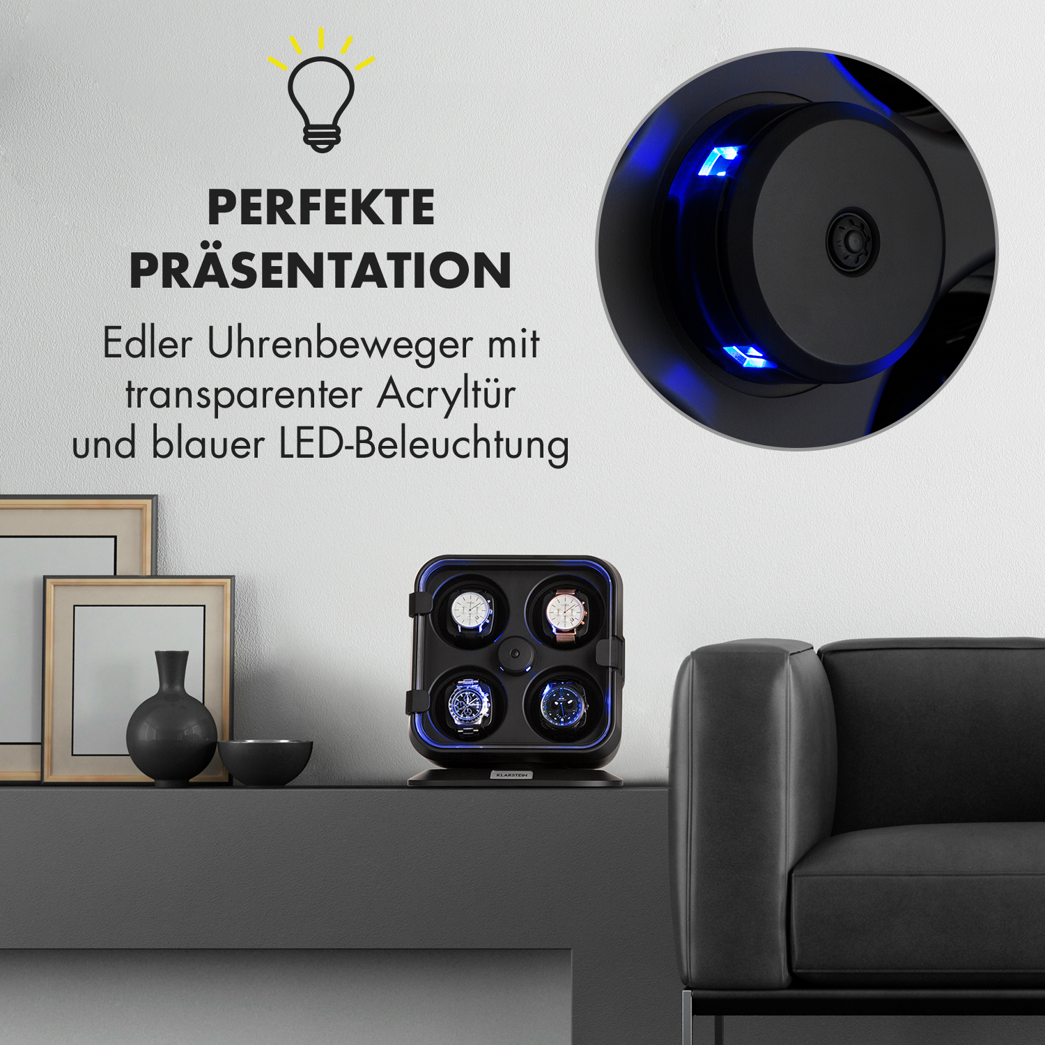 Ein Uhrenbeweger mit Uhren, ein schwarzes Sofa und Dekoration an einer weißen Wand.
