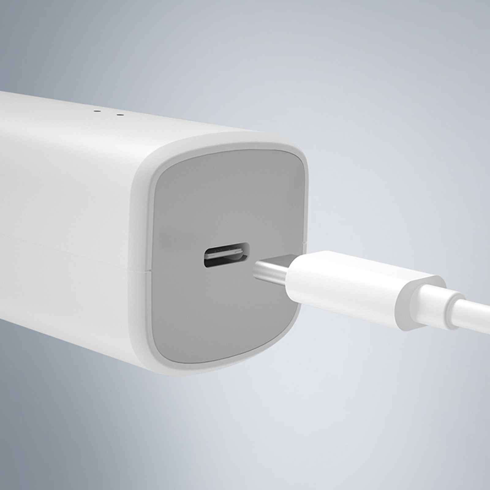 Ein weißes Ladegerät mit einem USB-C-Kabel. Der Hintergrund ist schlicht und unscharf.
