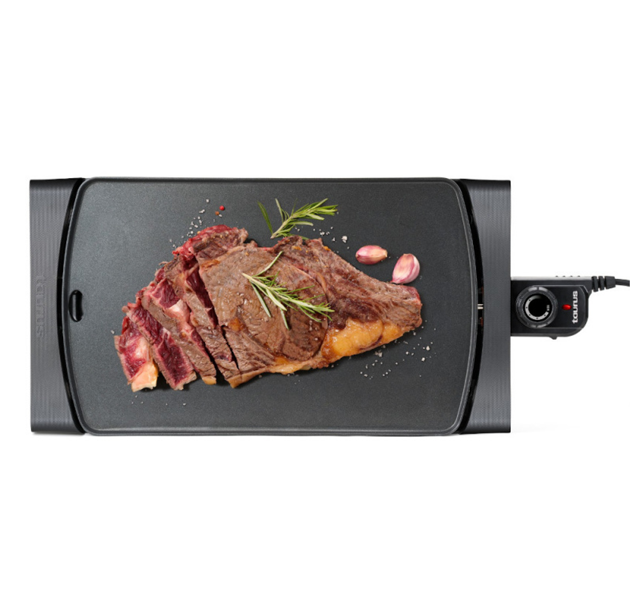 Geschnittenes Steak auf einem schwarzen Grill mit Rosmarin und Knoblauch.