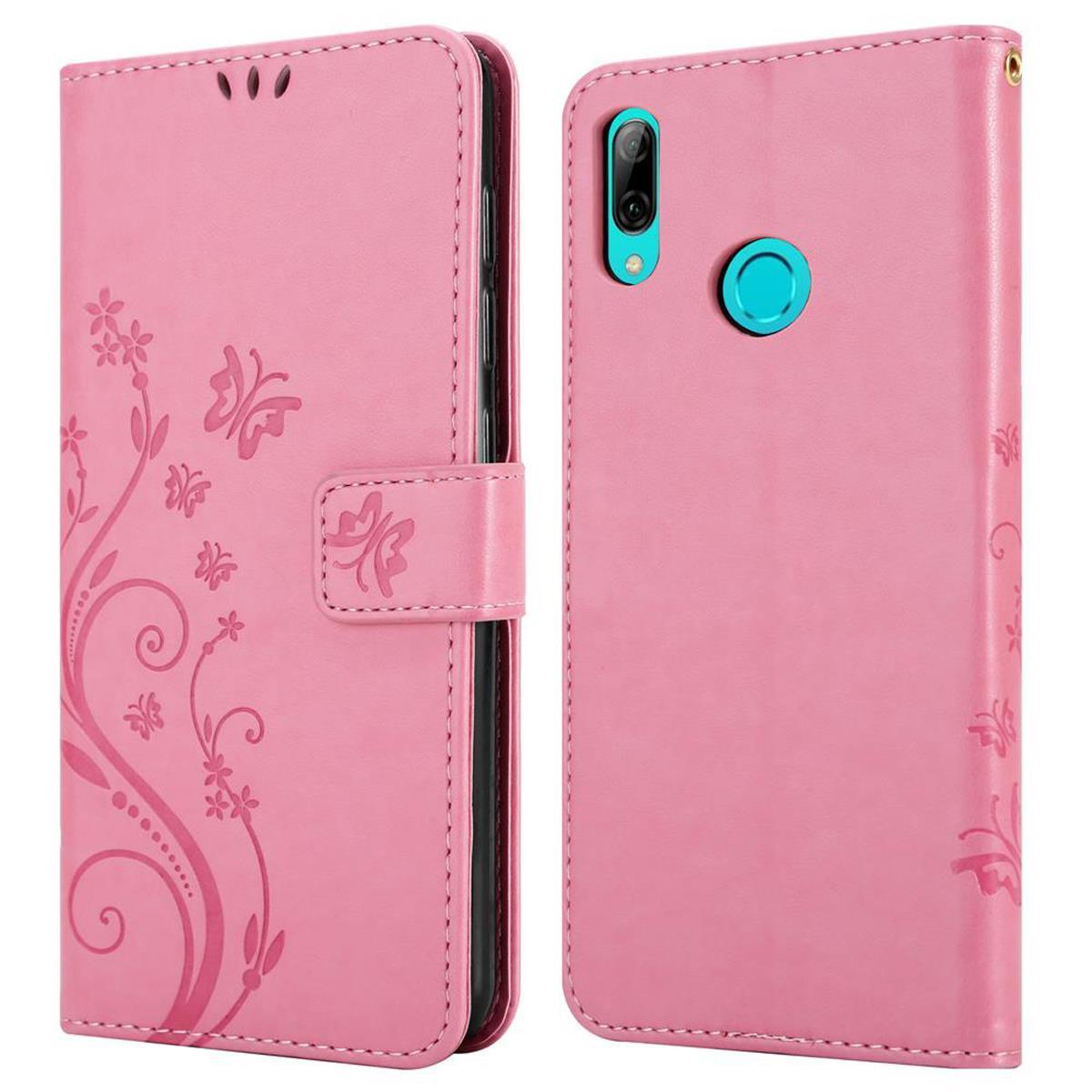 Custodia per telefono in pelle rosa, aperta, con design floreale. Il telefono ha una fotocamera e un cerchio turchese.