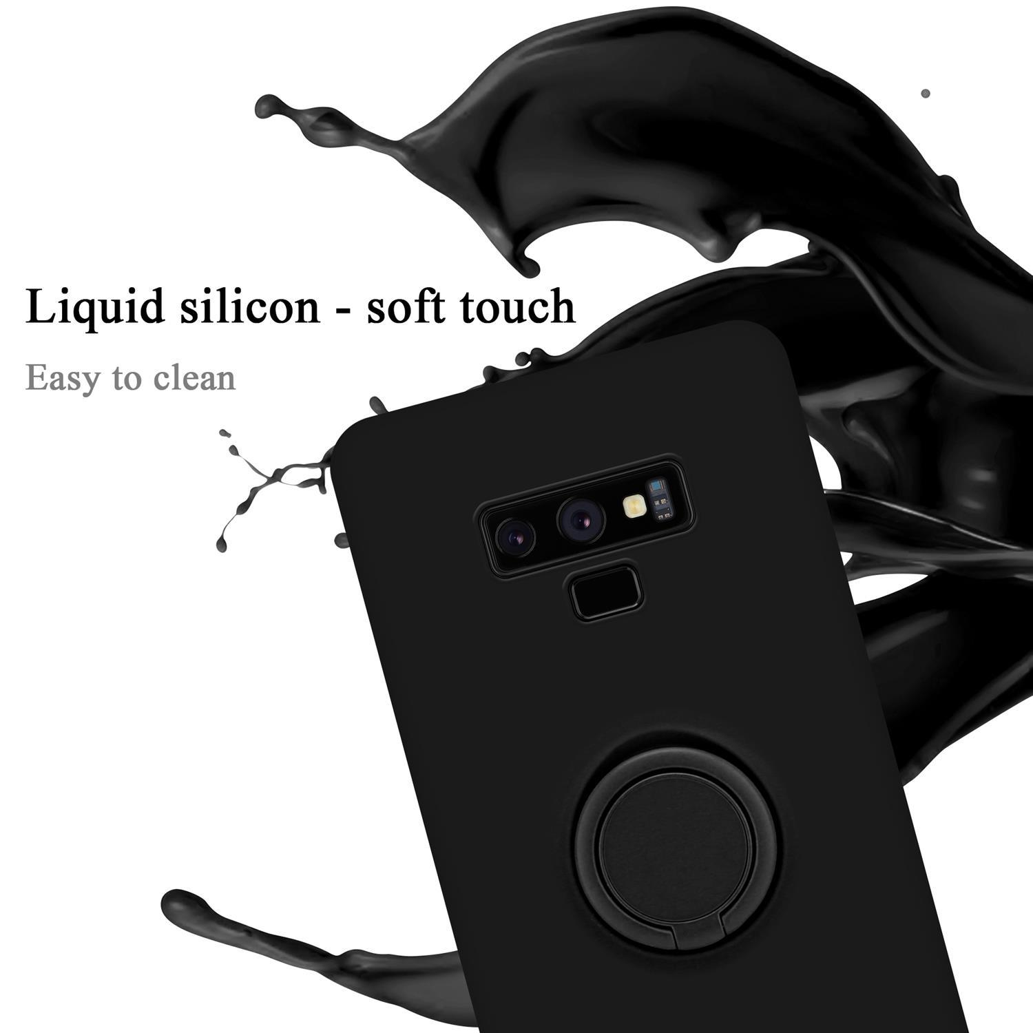 Custodia per telefono nera con supporto ad anello e spruzzo di liquido nero. Telefono parzialmente visibile.