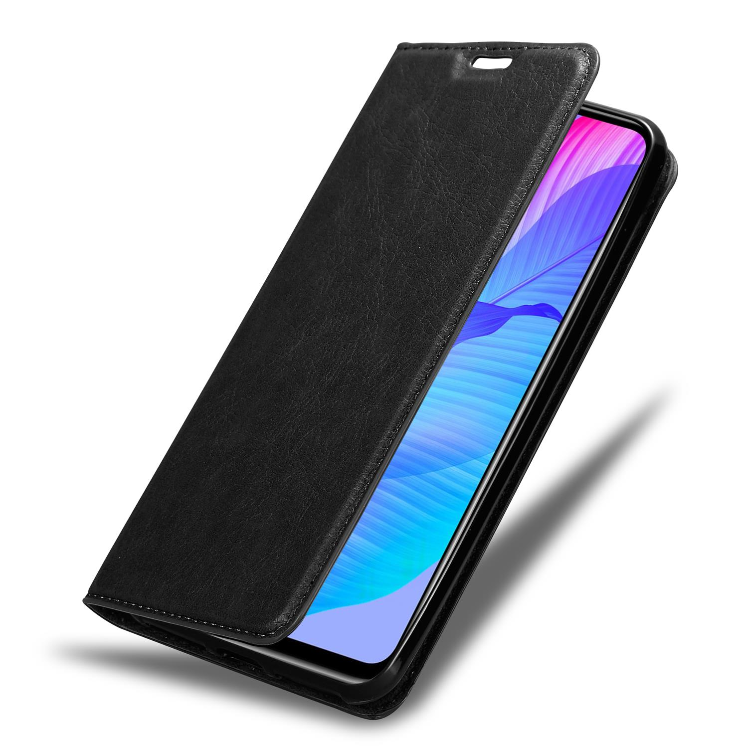 Geöffnete schwarze Handyhülle, die ein Handy zeigt. Lederstruktur, darunter rissiger Boden.