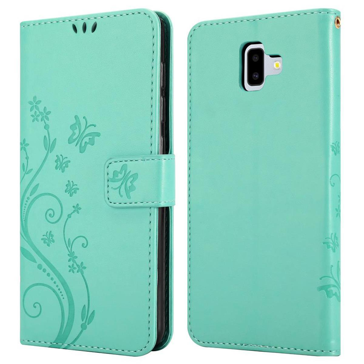Custodia per telefono in due parti; verde menta, design floreale, chiusura magnetica. Fotocamera e pulsanti visibili.
