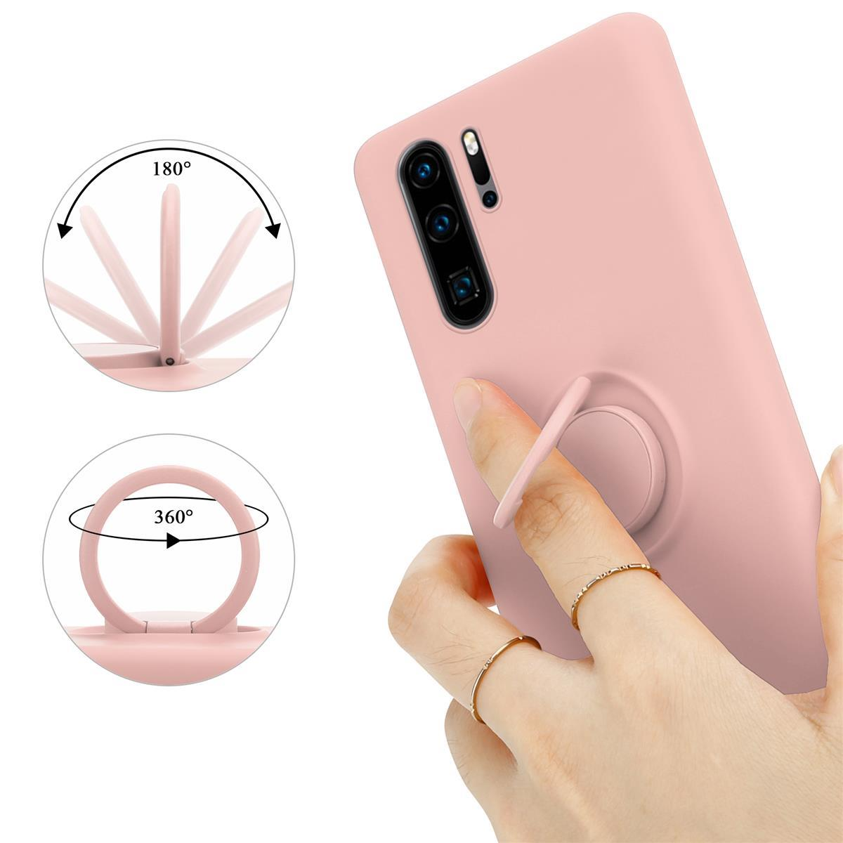 Custodia rosa per telefono con supporto ad anello. Mano che tiene il telefono. Un anello al dito.