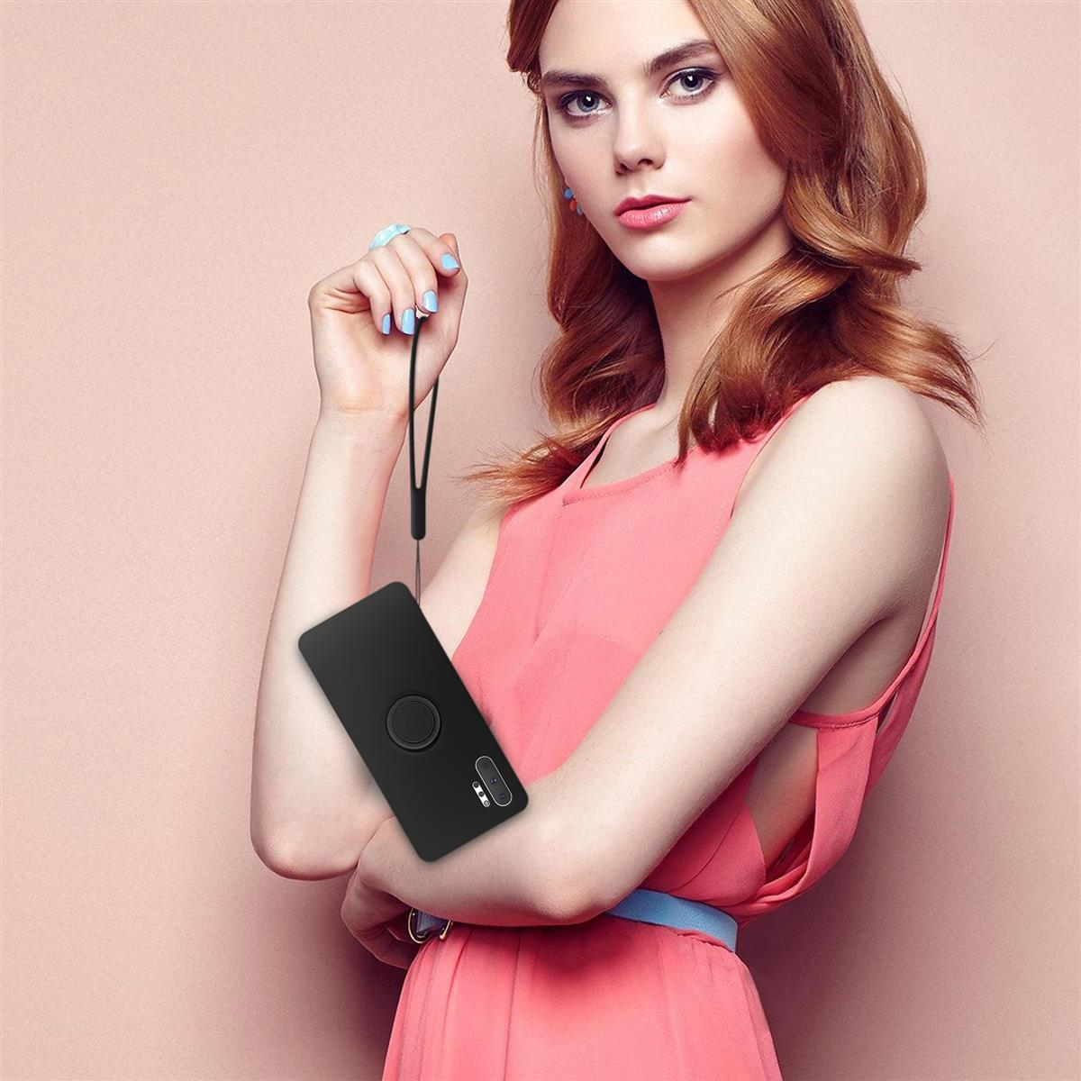 Donna che tiene in mano una custodia per telefono nera con un anello sul retro. Indossa una camicia rosa e una cintura blu.