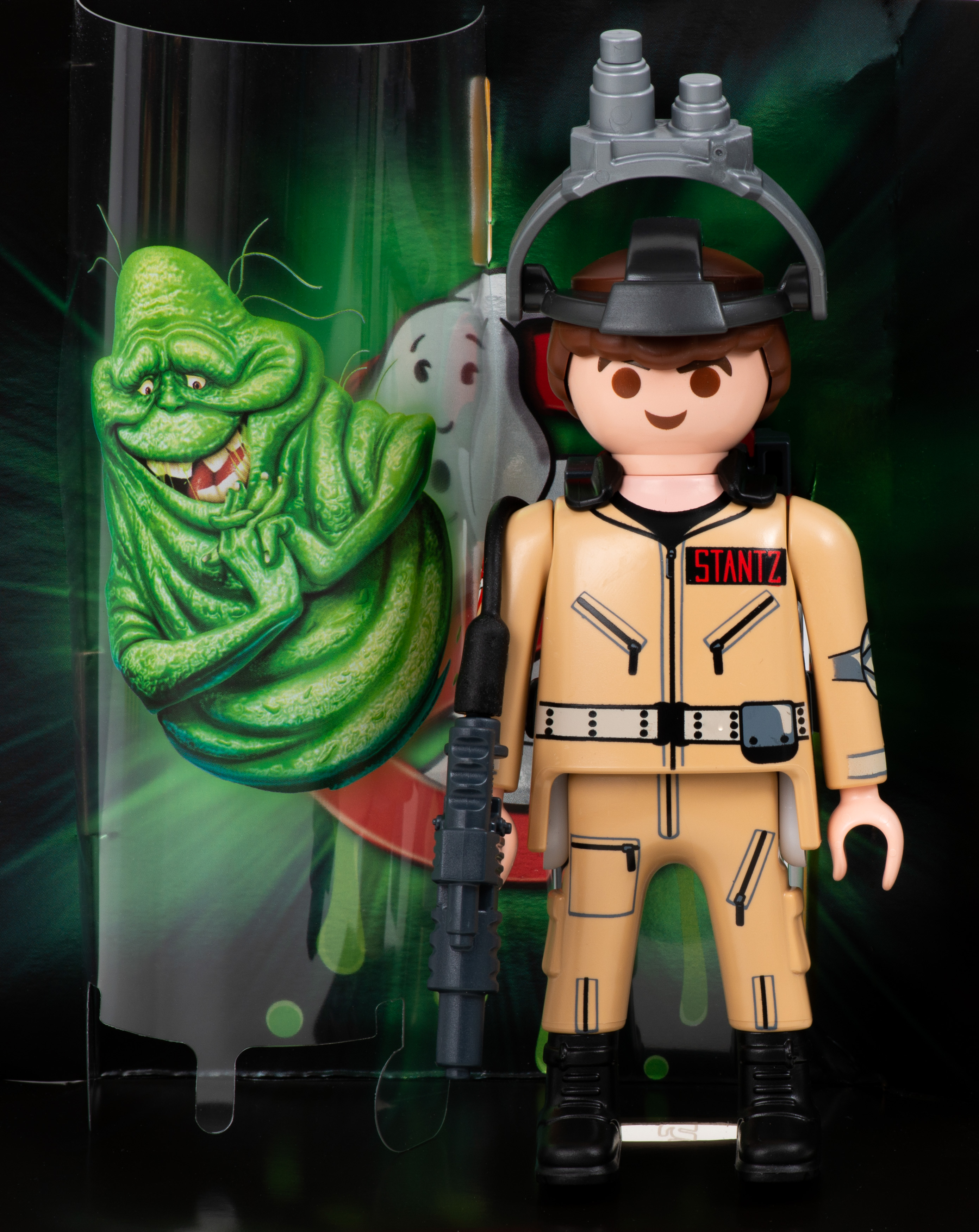 Una statuetta giocattolo dei Ghostbusters. La figura è davanti a uno sfondo verde.