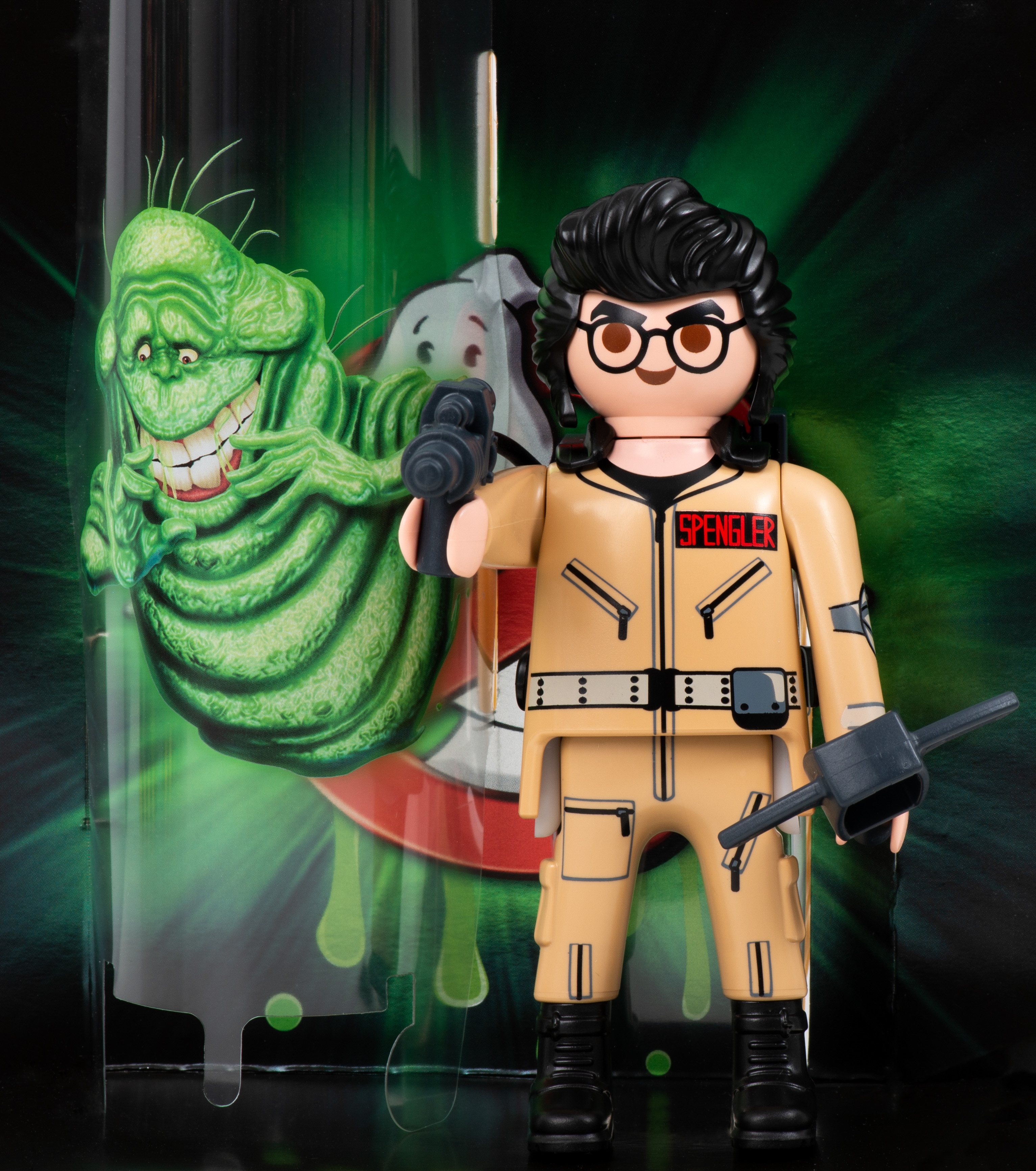 Figurka Playmobil Pogromcy Duchów, Spenglera, trzymającego broń. Zielony duch w tle.