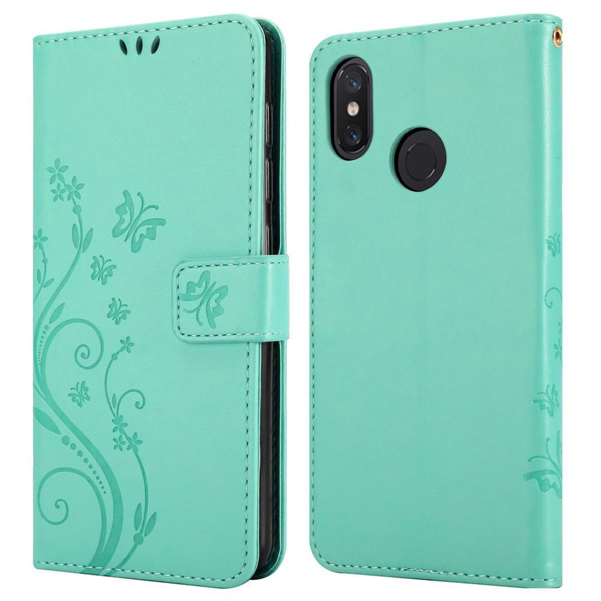 Una custodia per telefono color turchese con disegni floreali e chiusura magnetica.