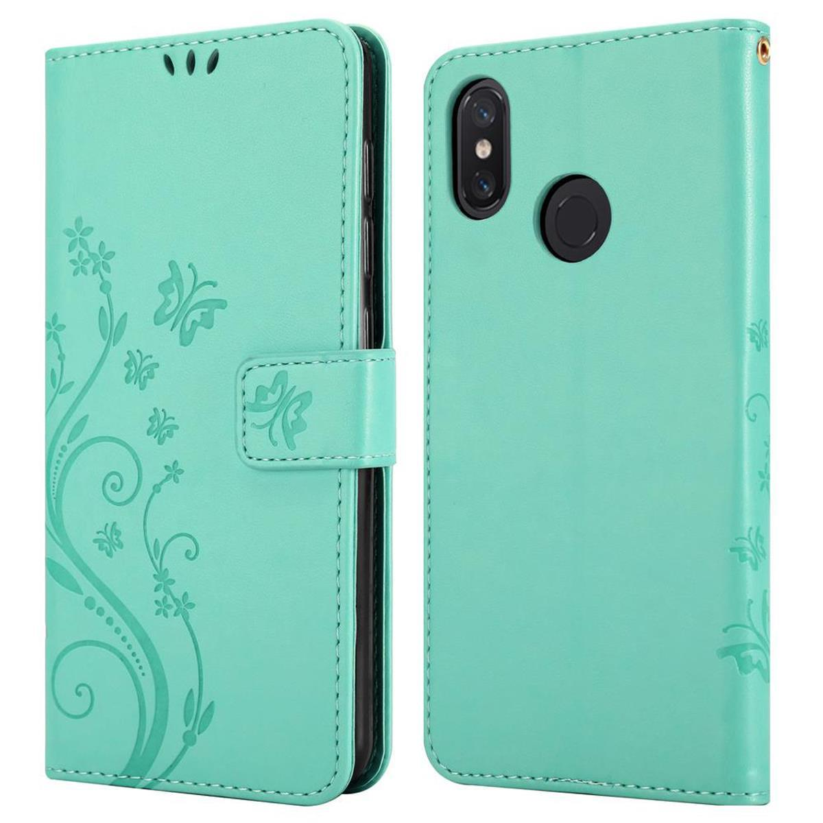 Una custodia per telefono verde acqua con un design floreale, aperta per mostrare il telefono.