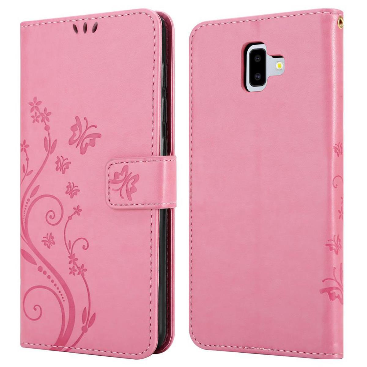 Viene mostrata una custodia a portafoglio rosa. Presenta motivi floreali e una chiusura magnetica.