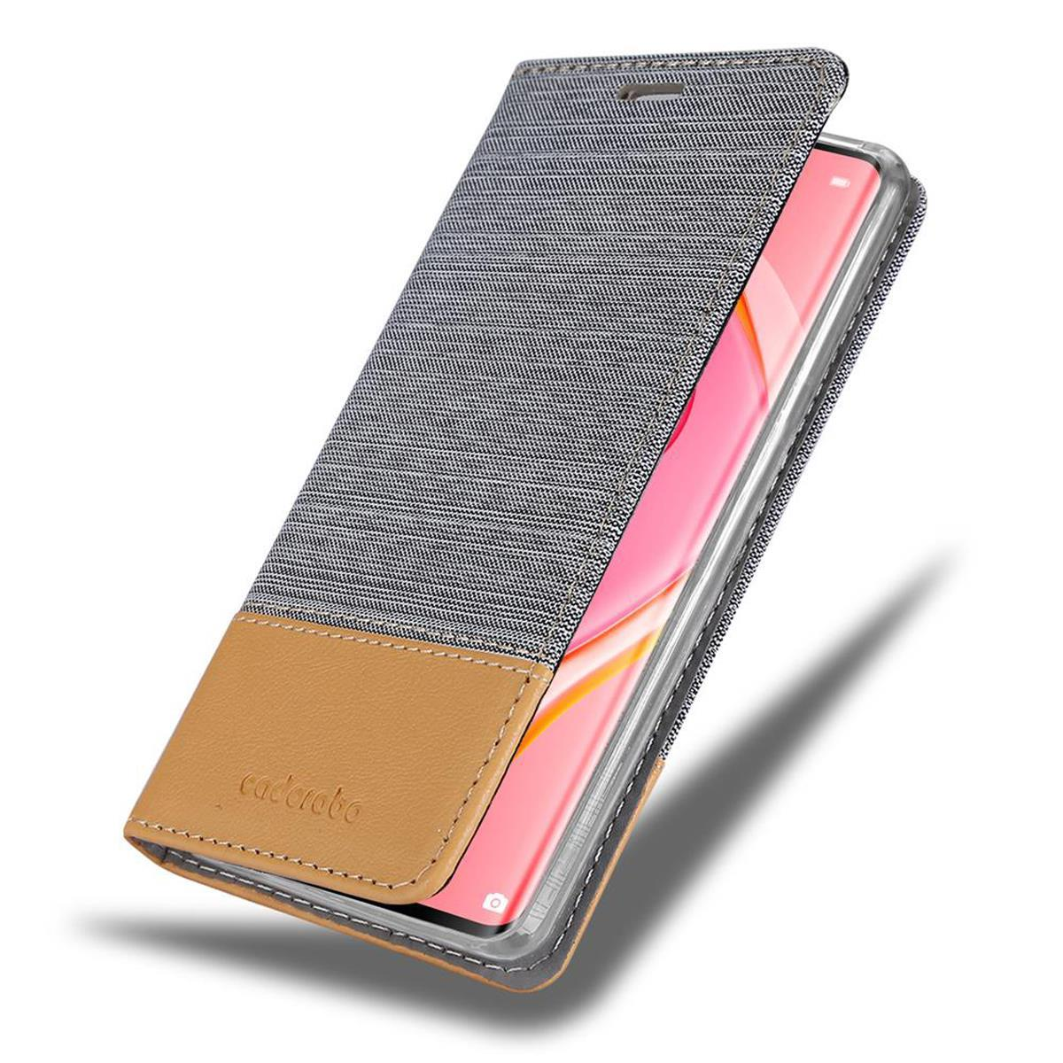 Telefon in einer Denim- und braunen Lederhülle. Weißer Hintergrund. Hülle ist Denim und braun. Rosa Telefon.