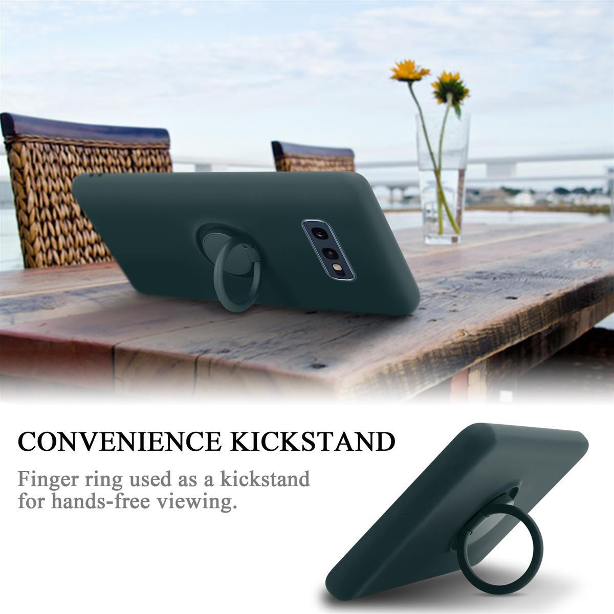 Telefono con supporto ad anello, posto su un tavolo di legno. Ci sono fiori in un vaso sullo sfondo.