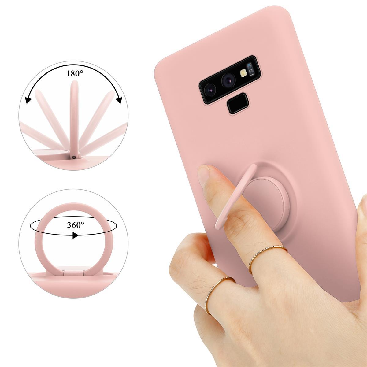 Una custodia rosa con un supporto ad anello è mostrata. Una mano sta usando il supporto.